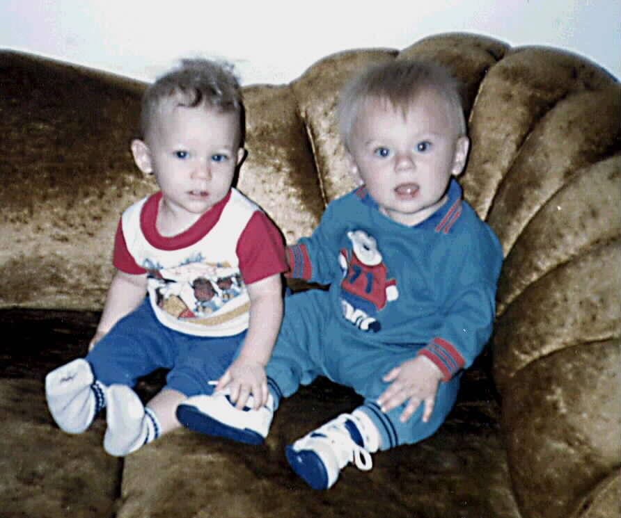 Two babies sitting on a couch