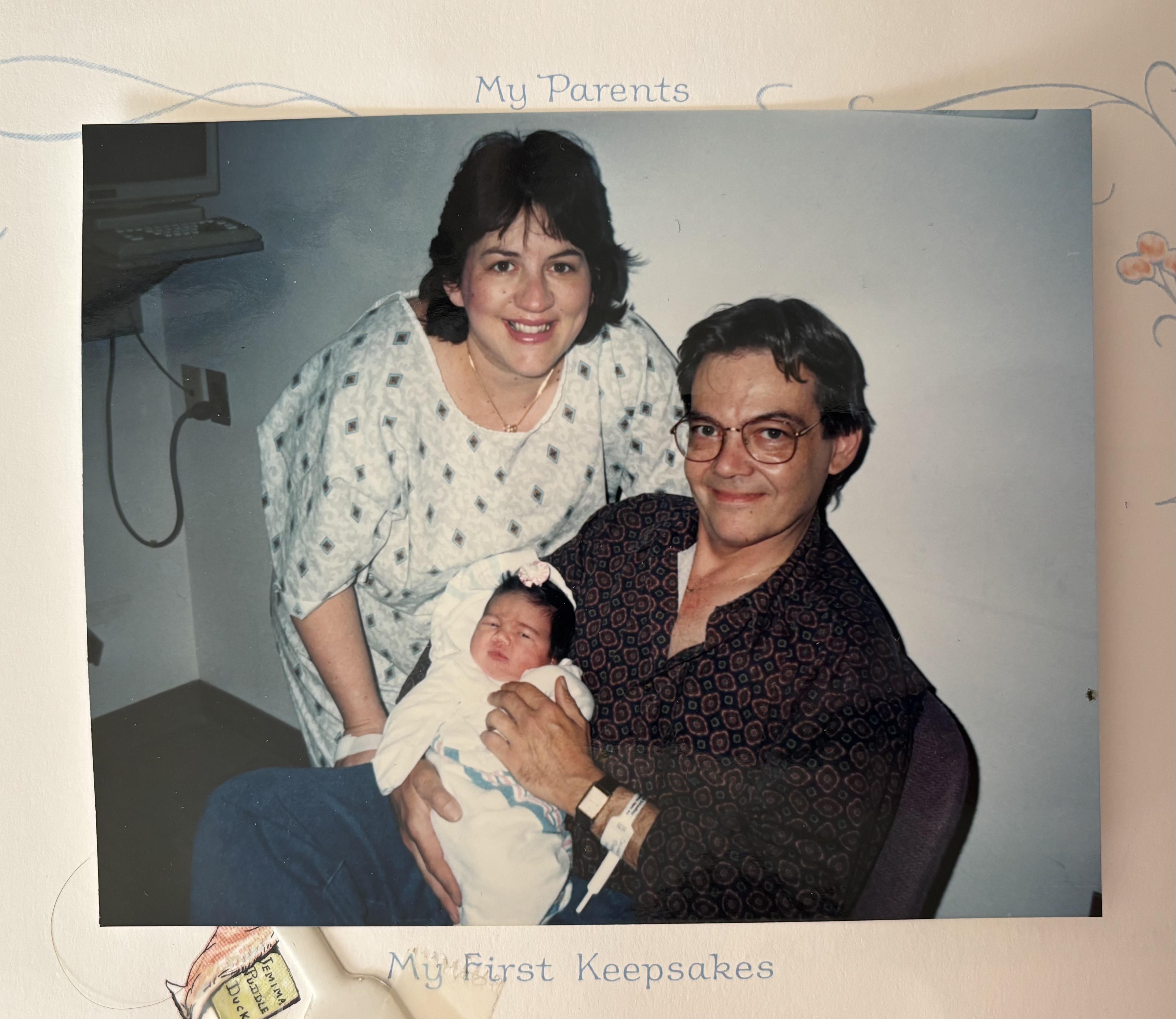 A man and woman holding a baby