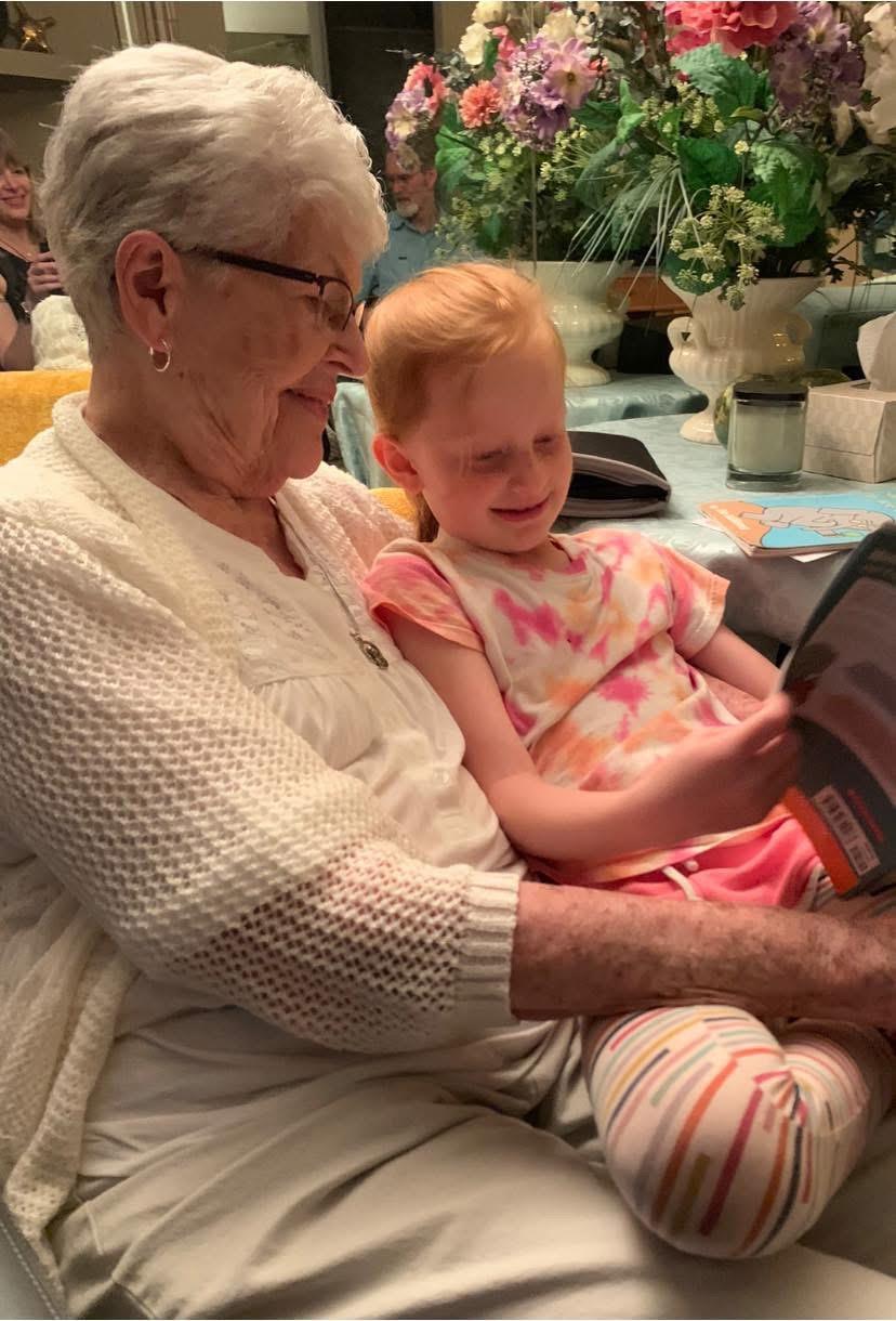 An older woman and a young girl reading a book
