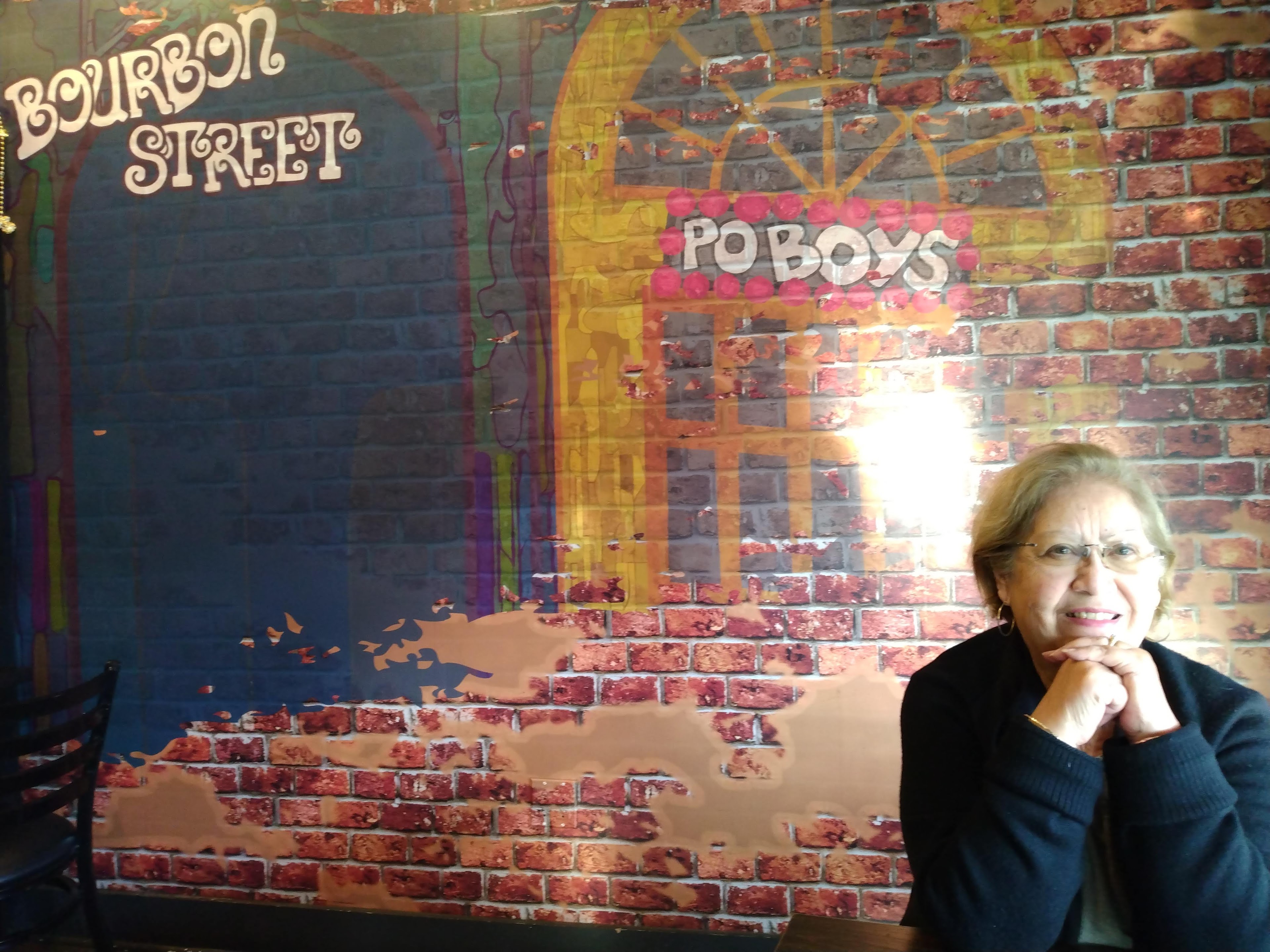 A woman sitting in front of a brick wall