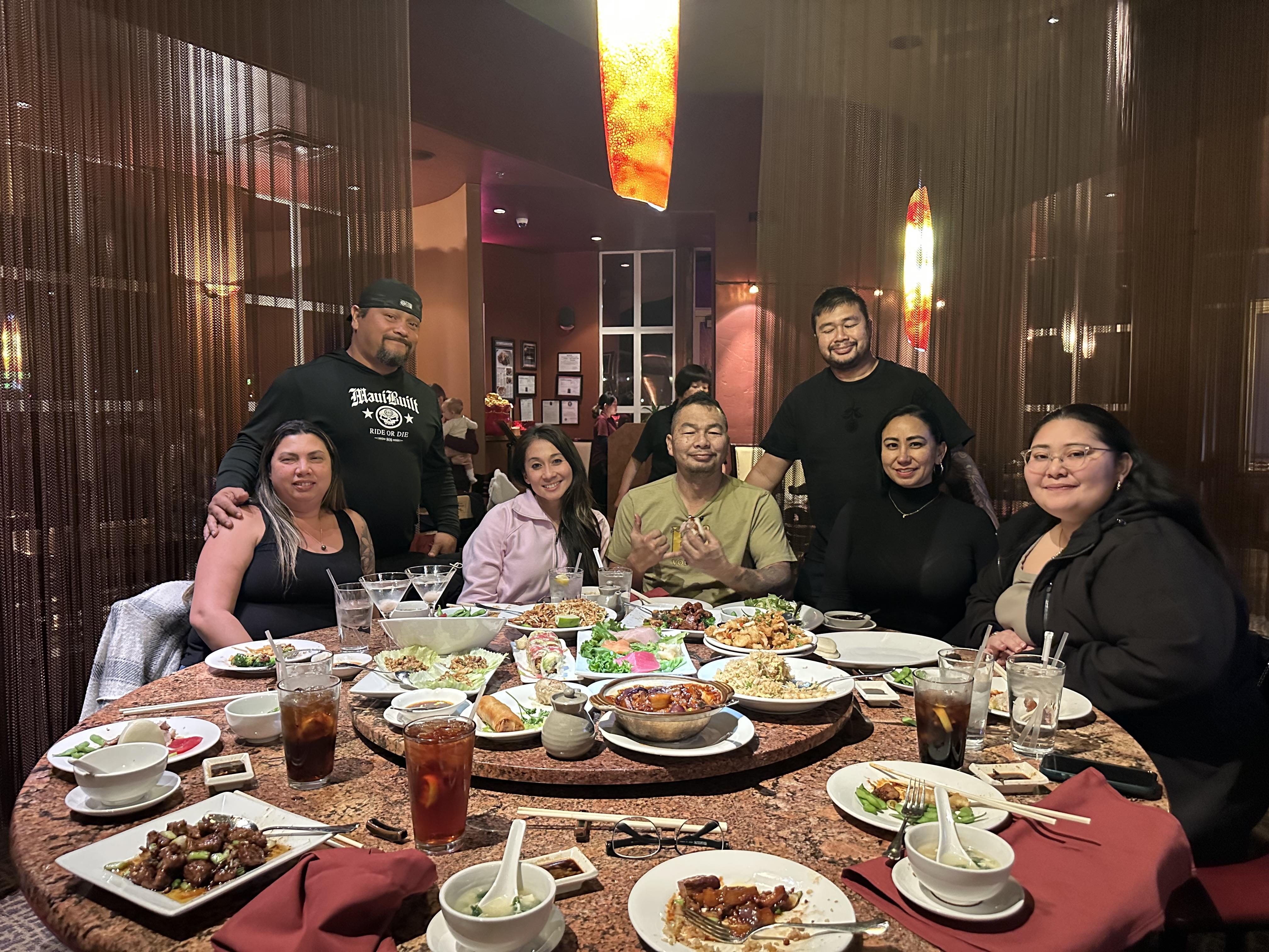 A group of people around a table with food