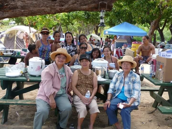 A group of people sitting under a tree