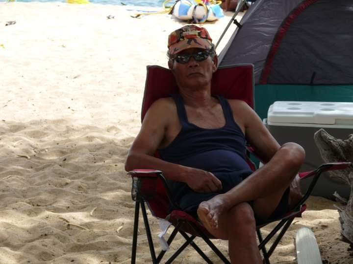 A man sitting in a chair on the beach