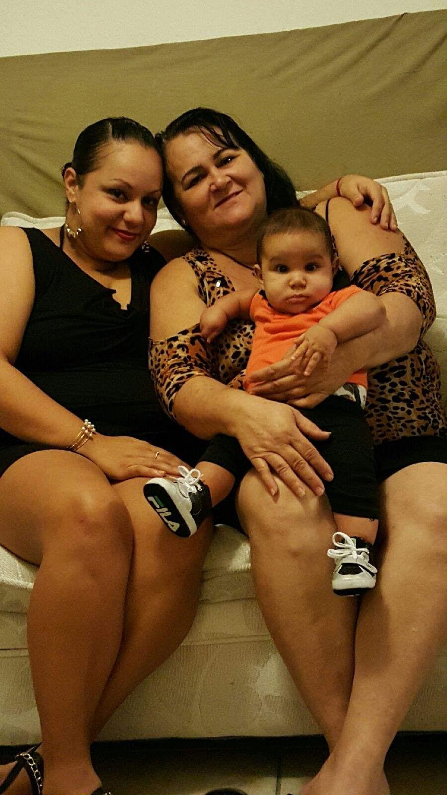 Two women sitting on a bed with a baby