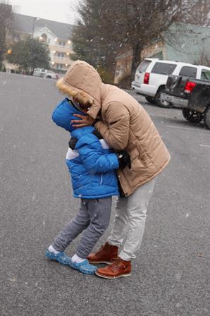 A woman and child kissing in the snow
