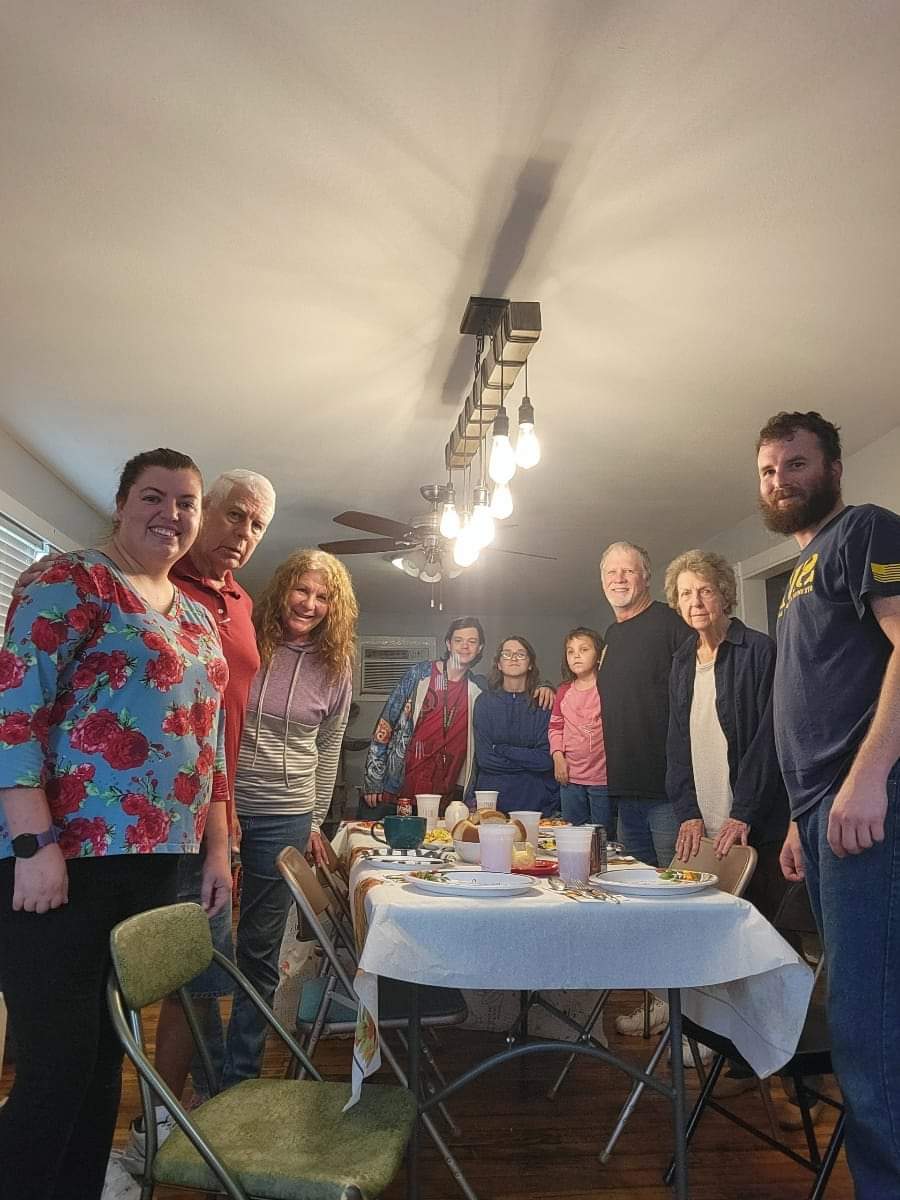 A group of people standing around a table