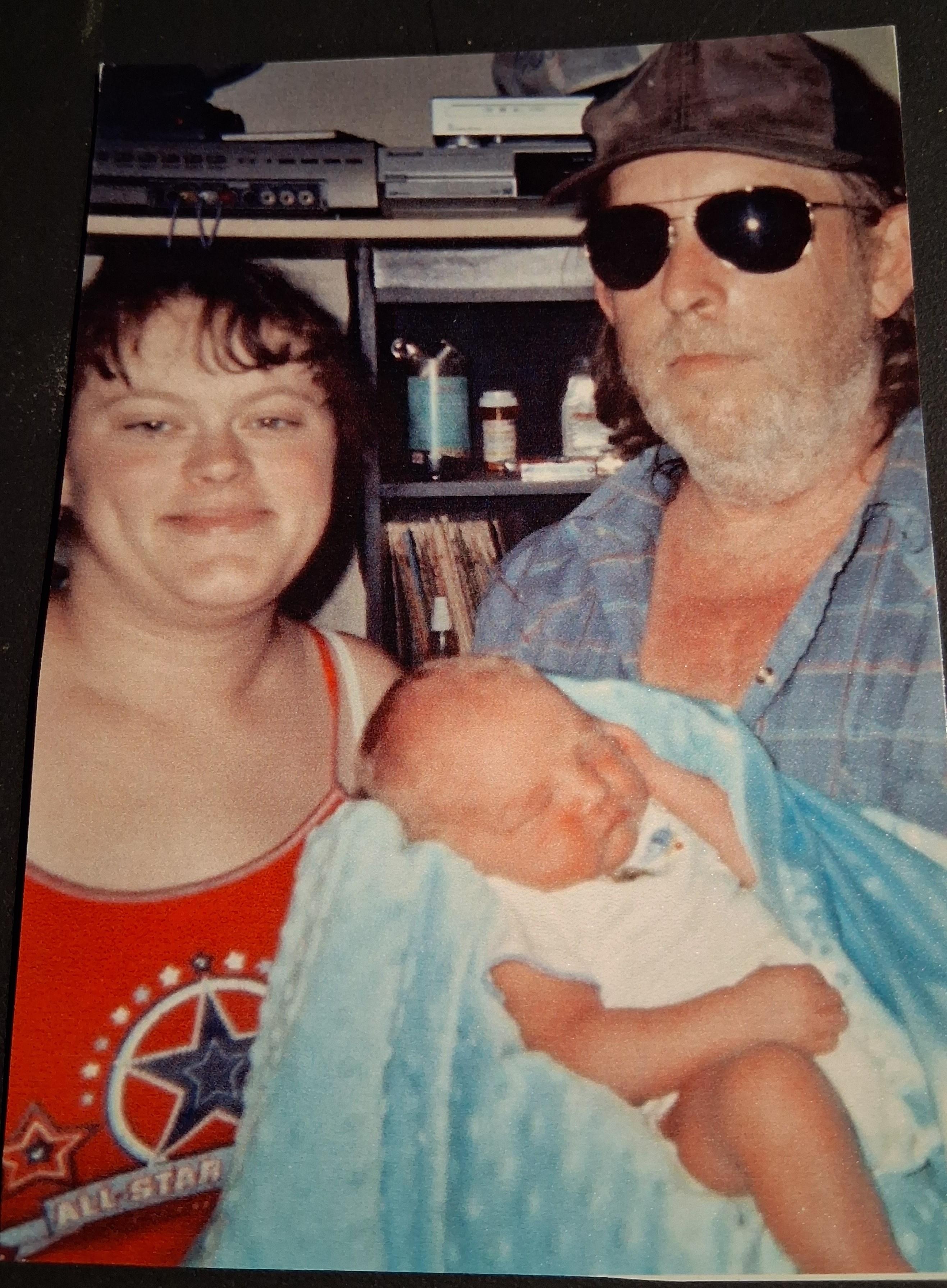 A man and woman holding a baby