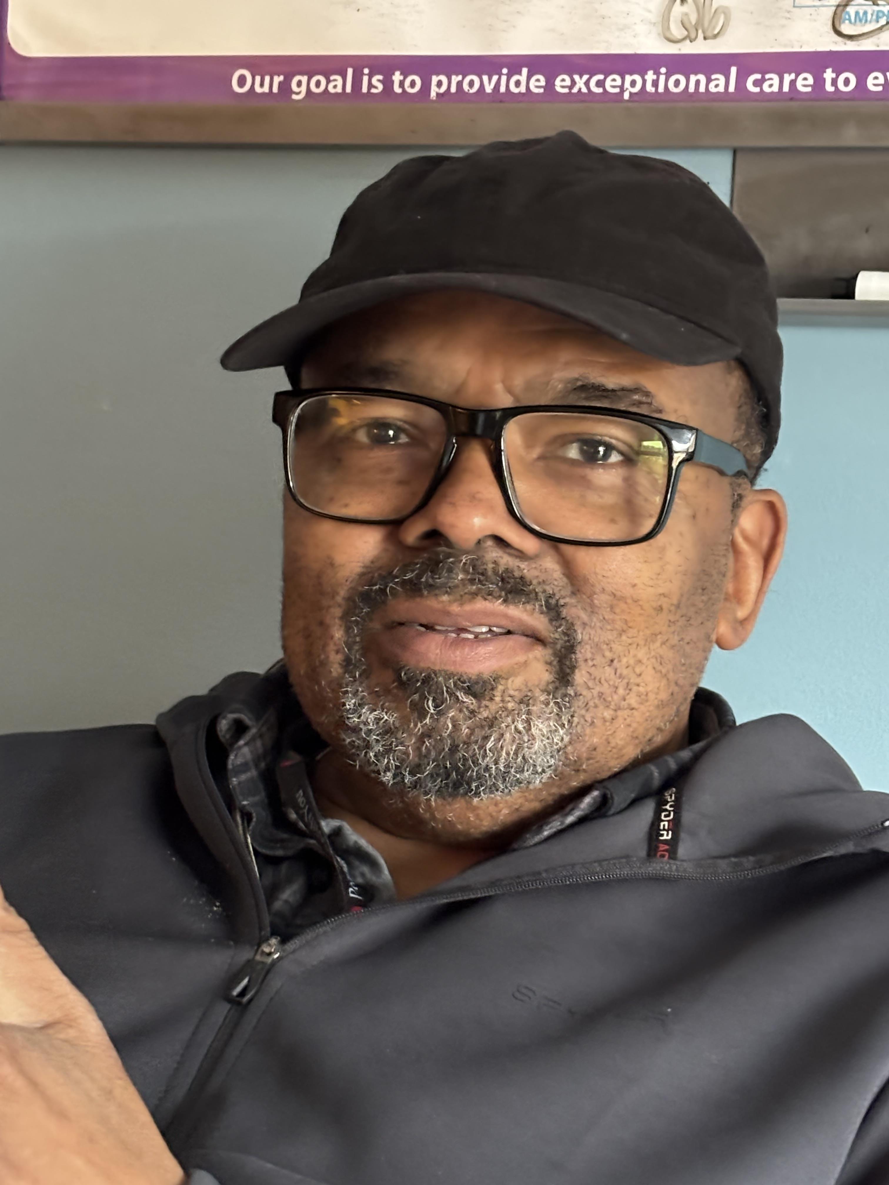 A man wearing a hat and glasses