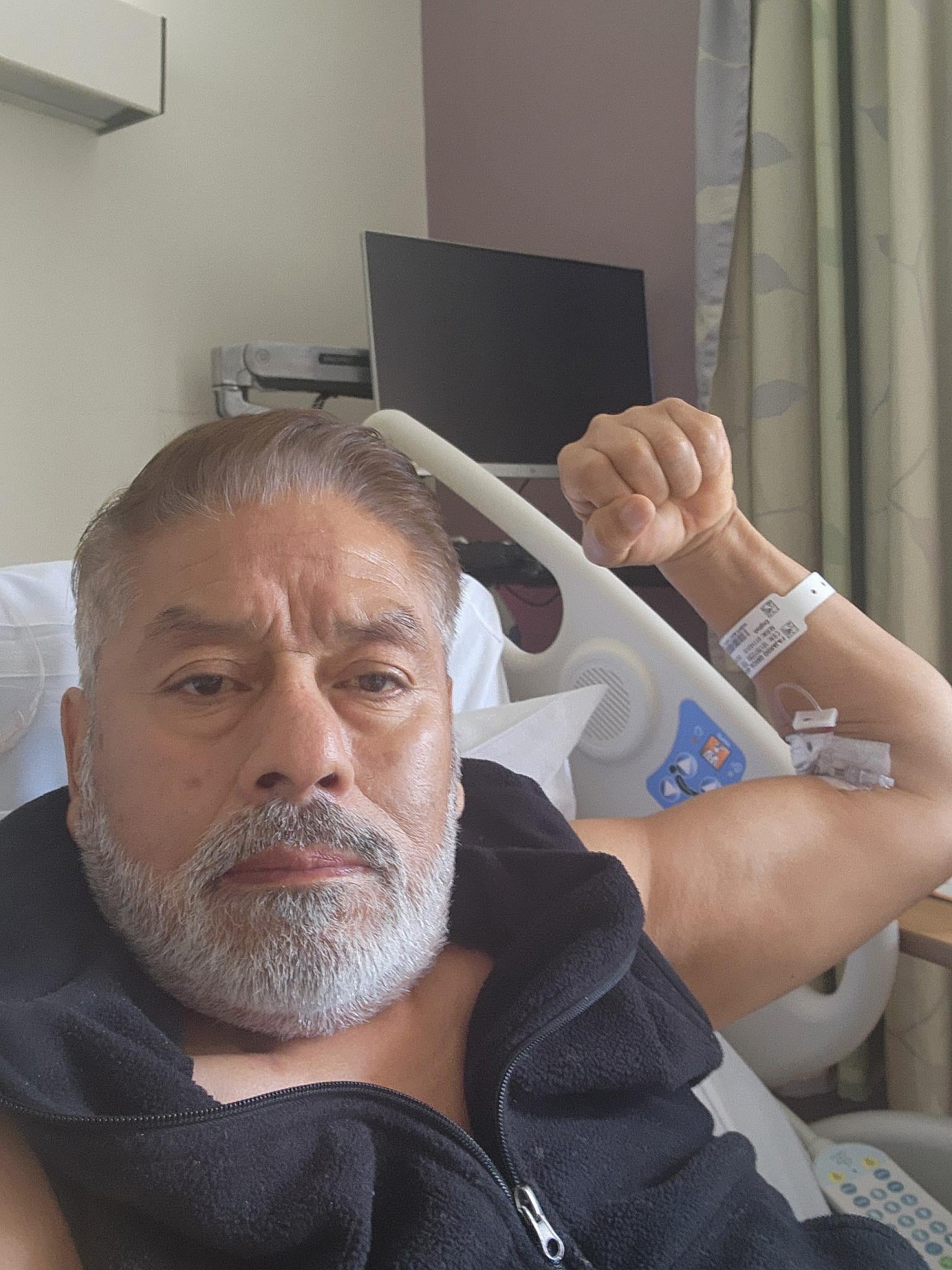 A man in a hospital bed holding a white object