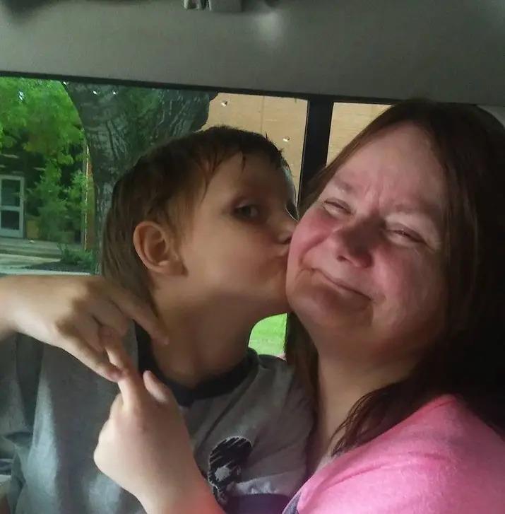 A boy kissing a woman's cheek