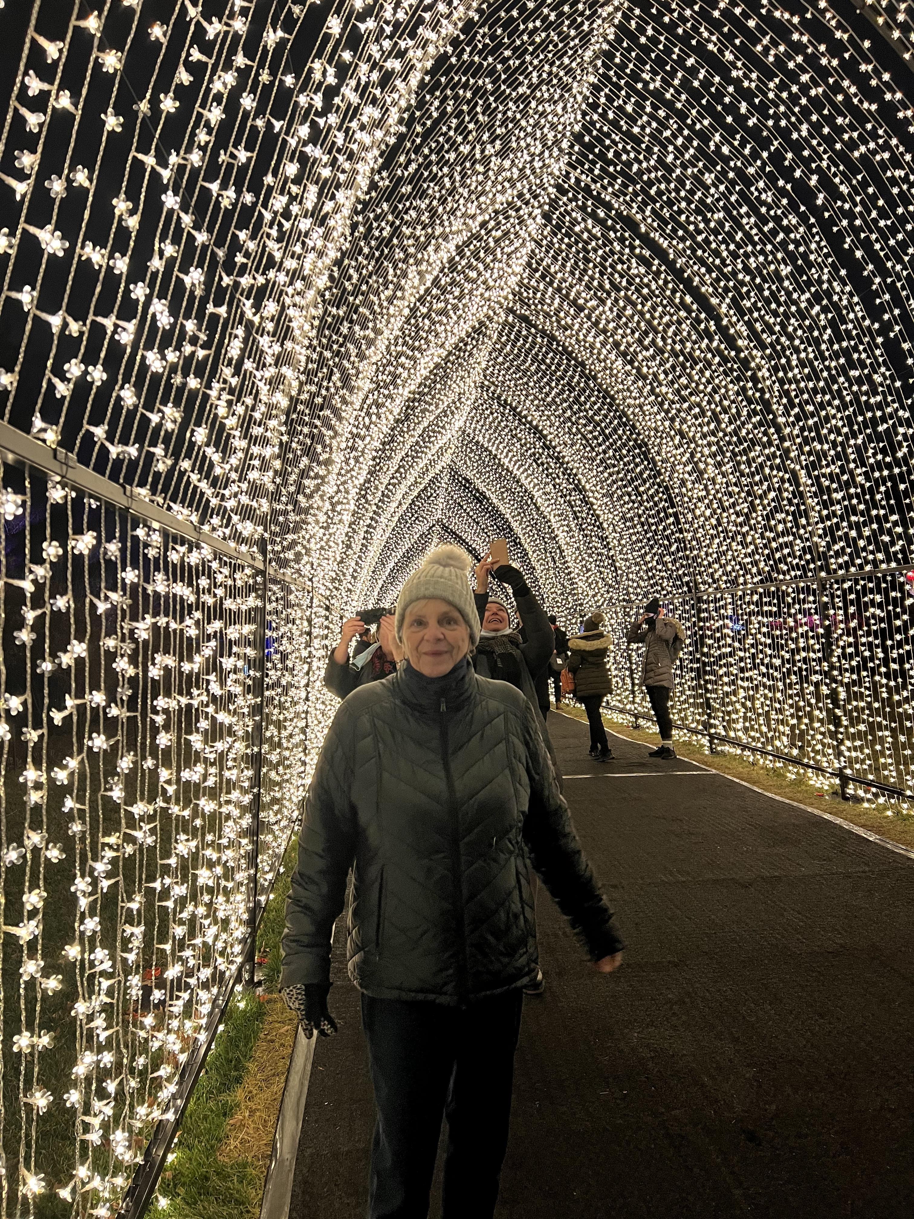 A woman standing in a tunnel with lights