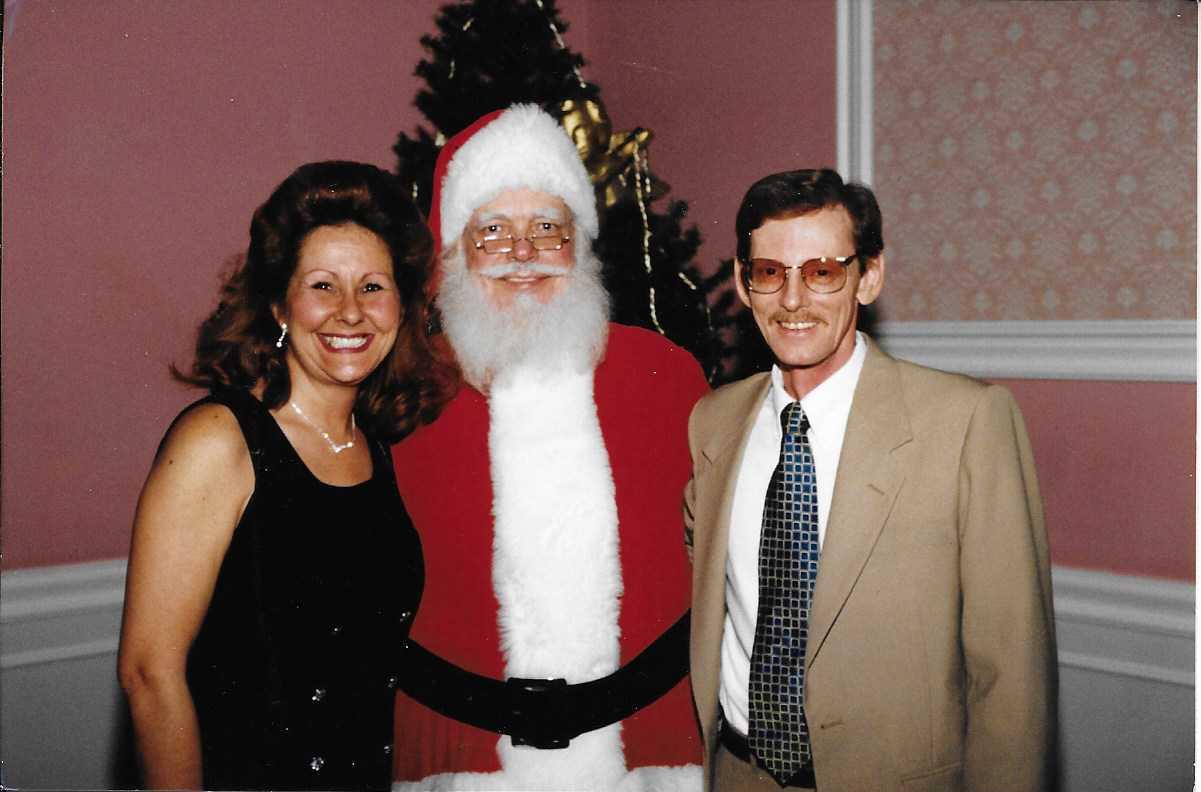 A man and woman standing next to a santa claus