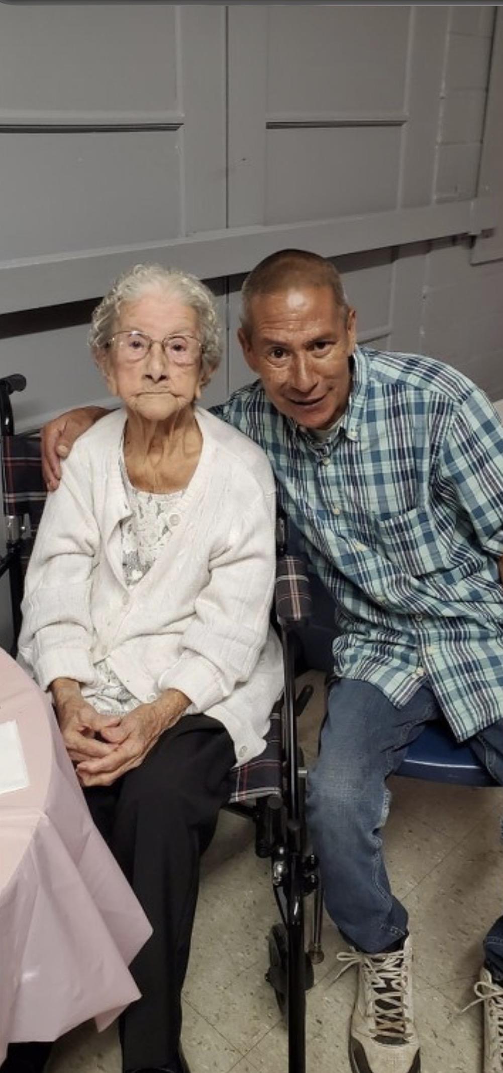 A man and woman sitting in a wheelchair