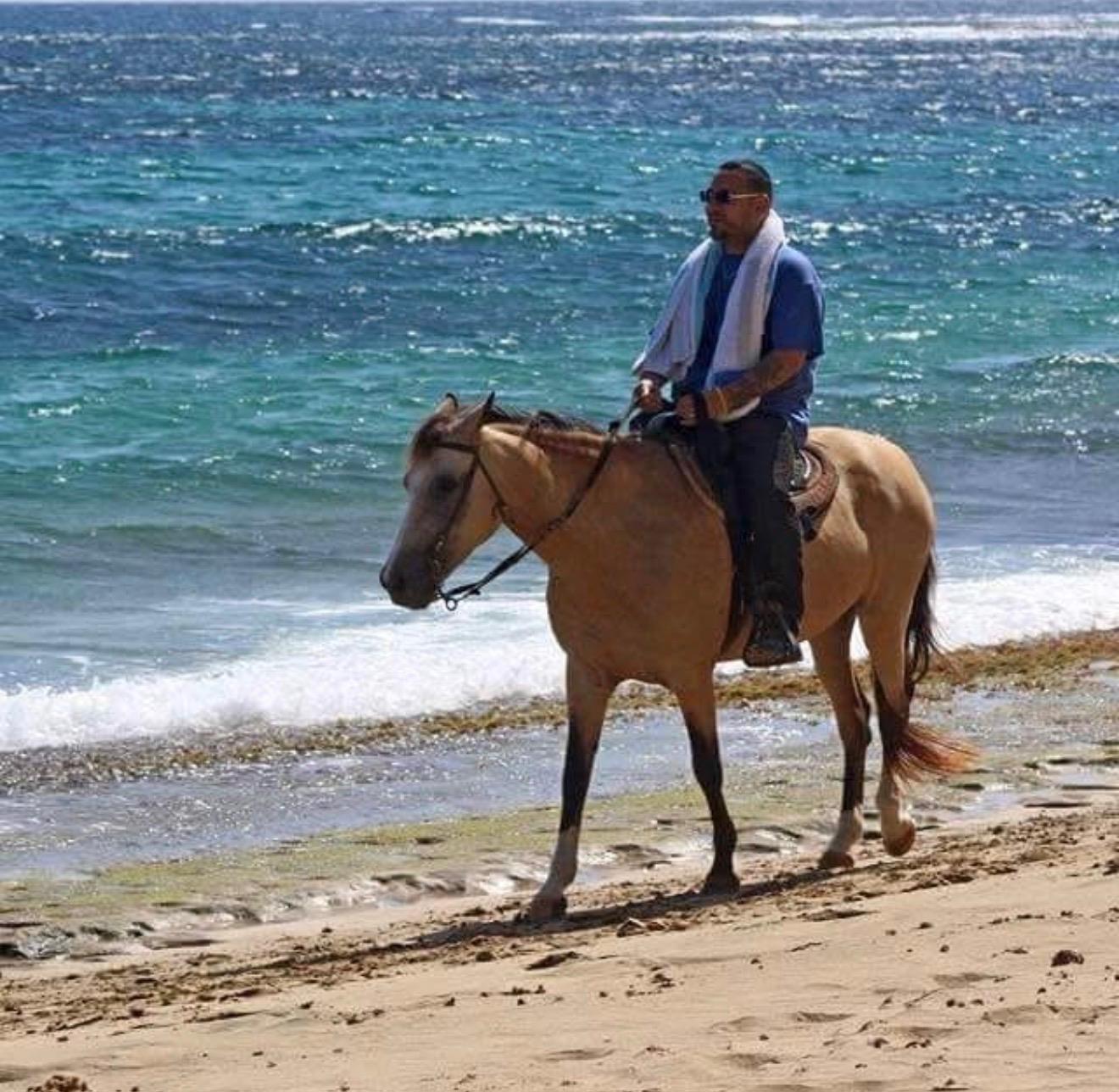 A man riding a horse on a beach