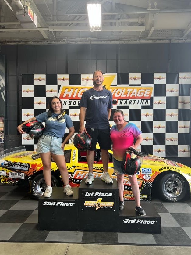 A group of people standing in front of a race car