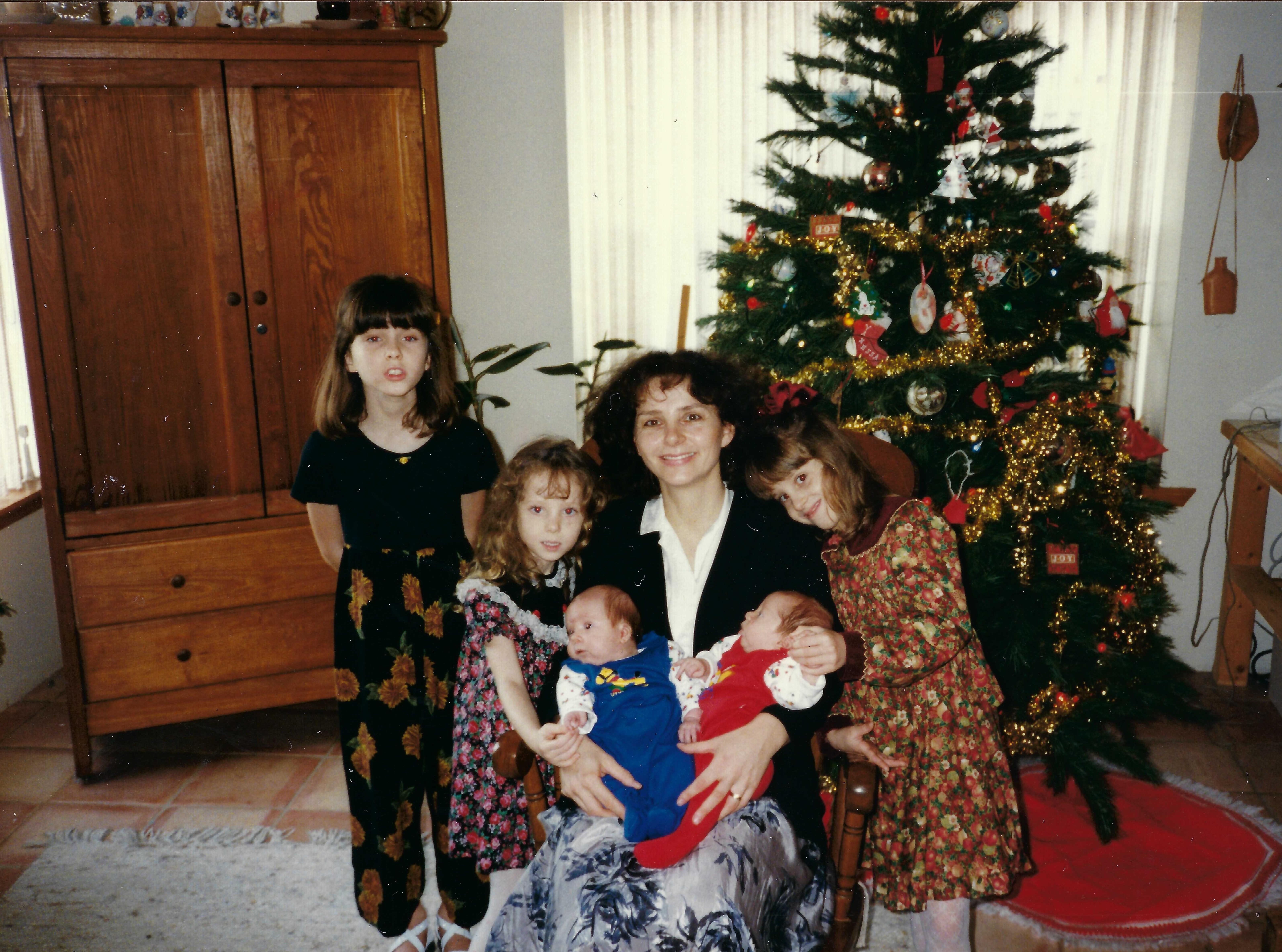 A woman holding a baby and a group of children