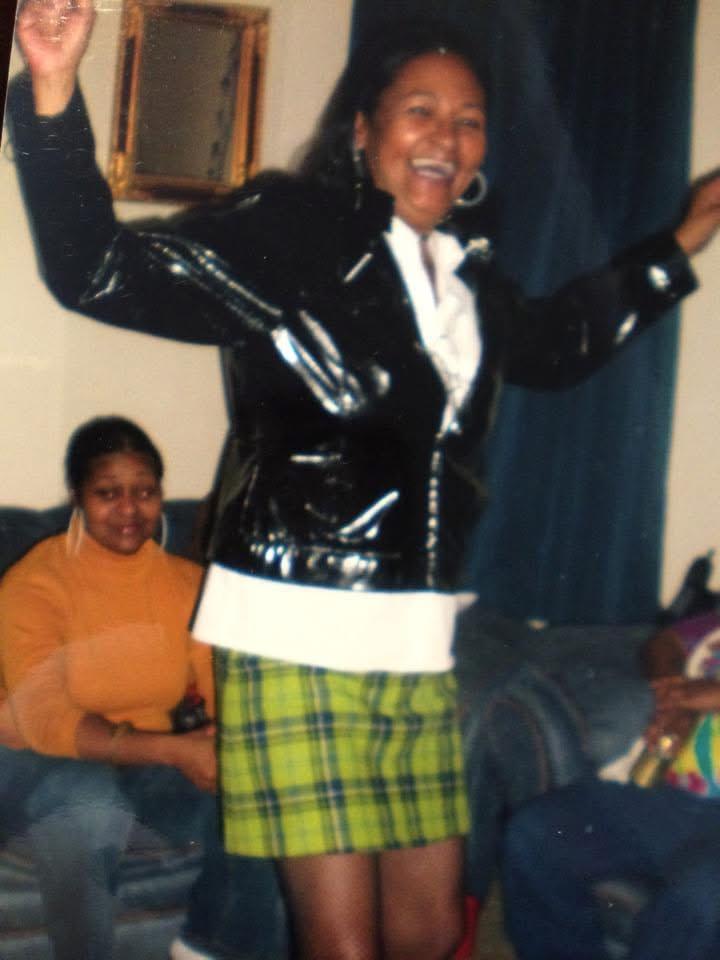 A woman in a black jacket and green plaid skirt