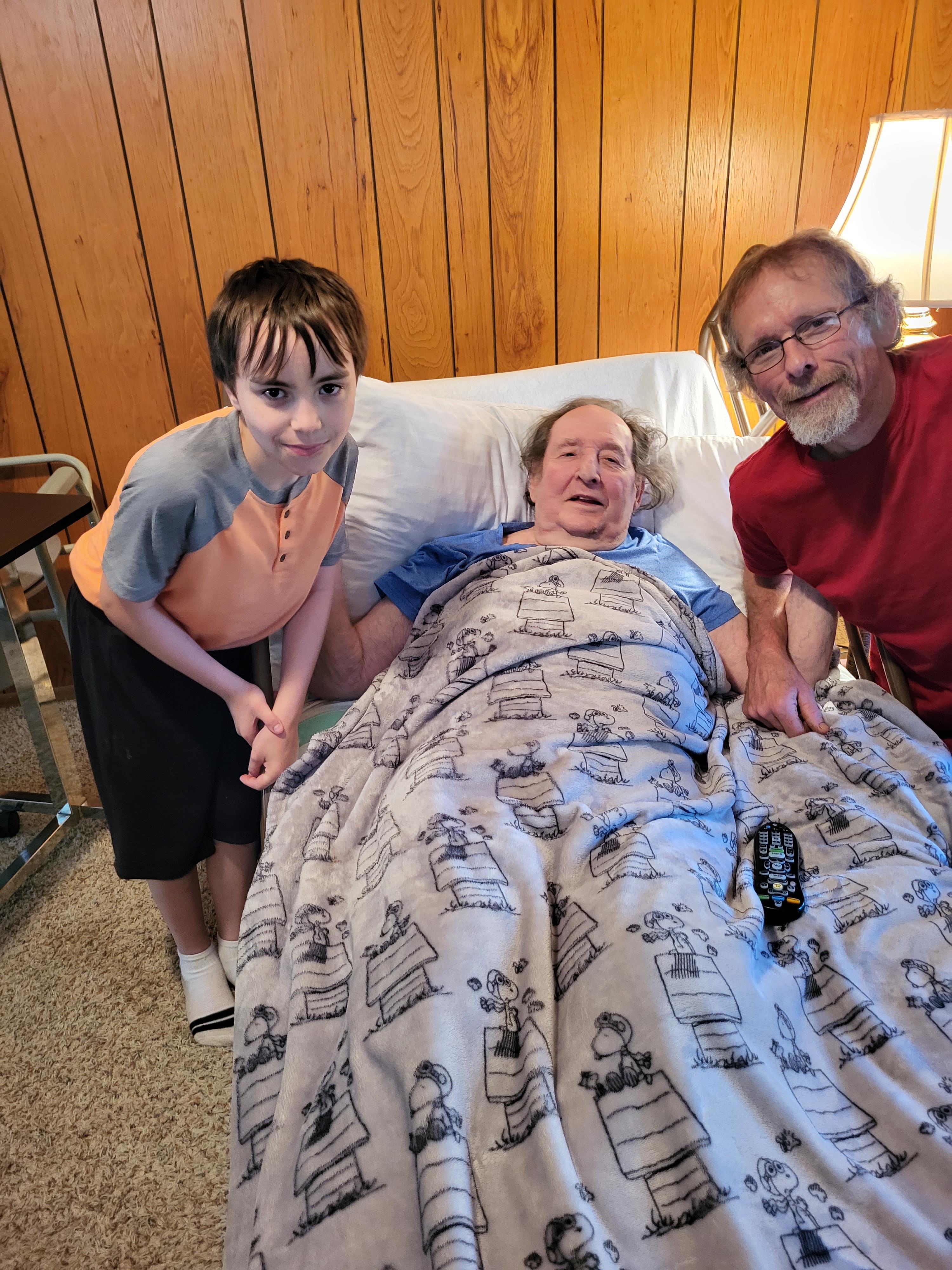 A man and a boy in a bed with a woman