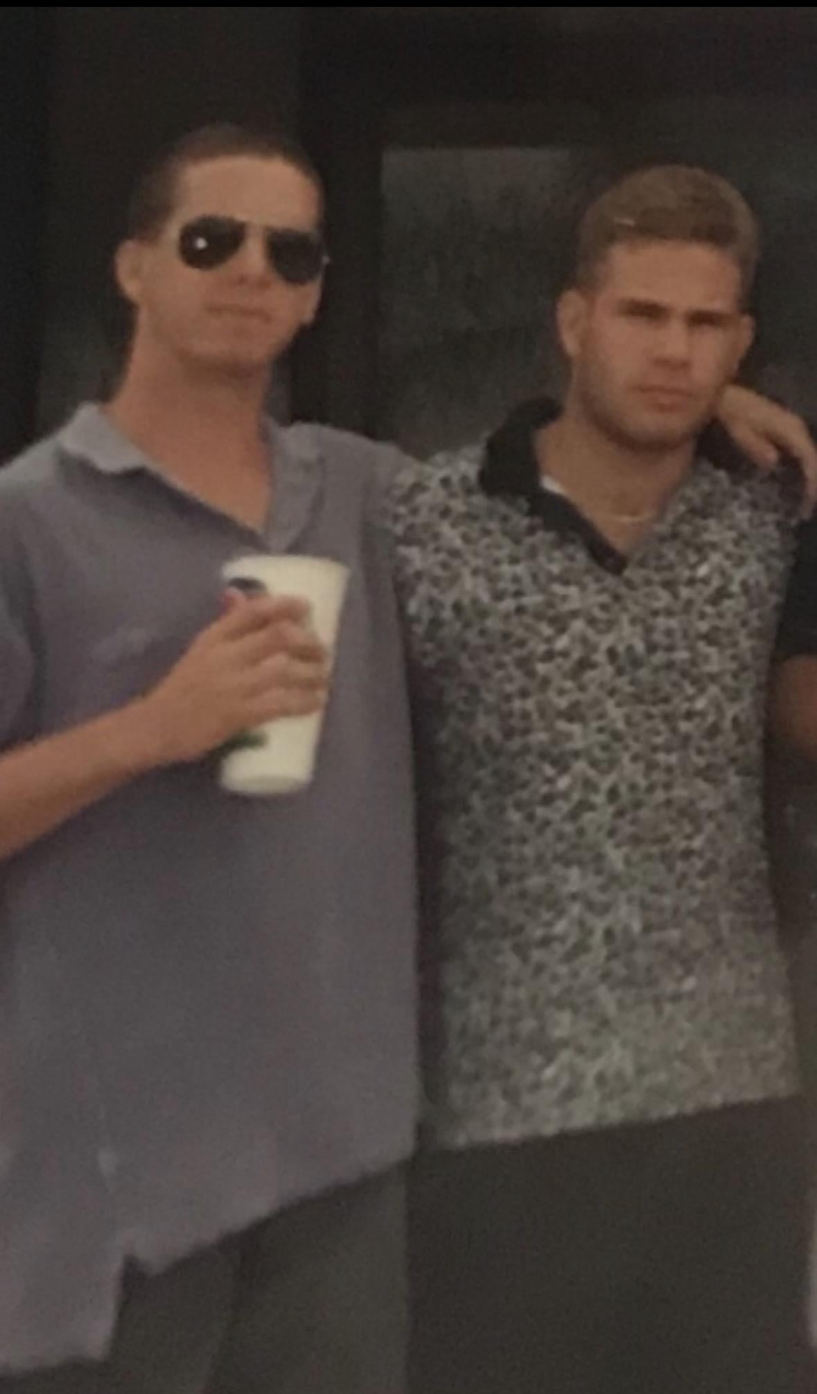 Two men standing together holding cups