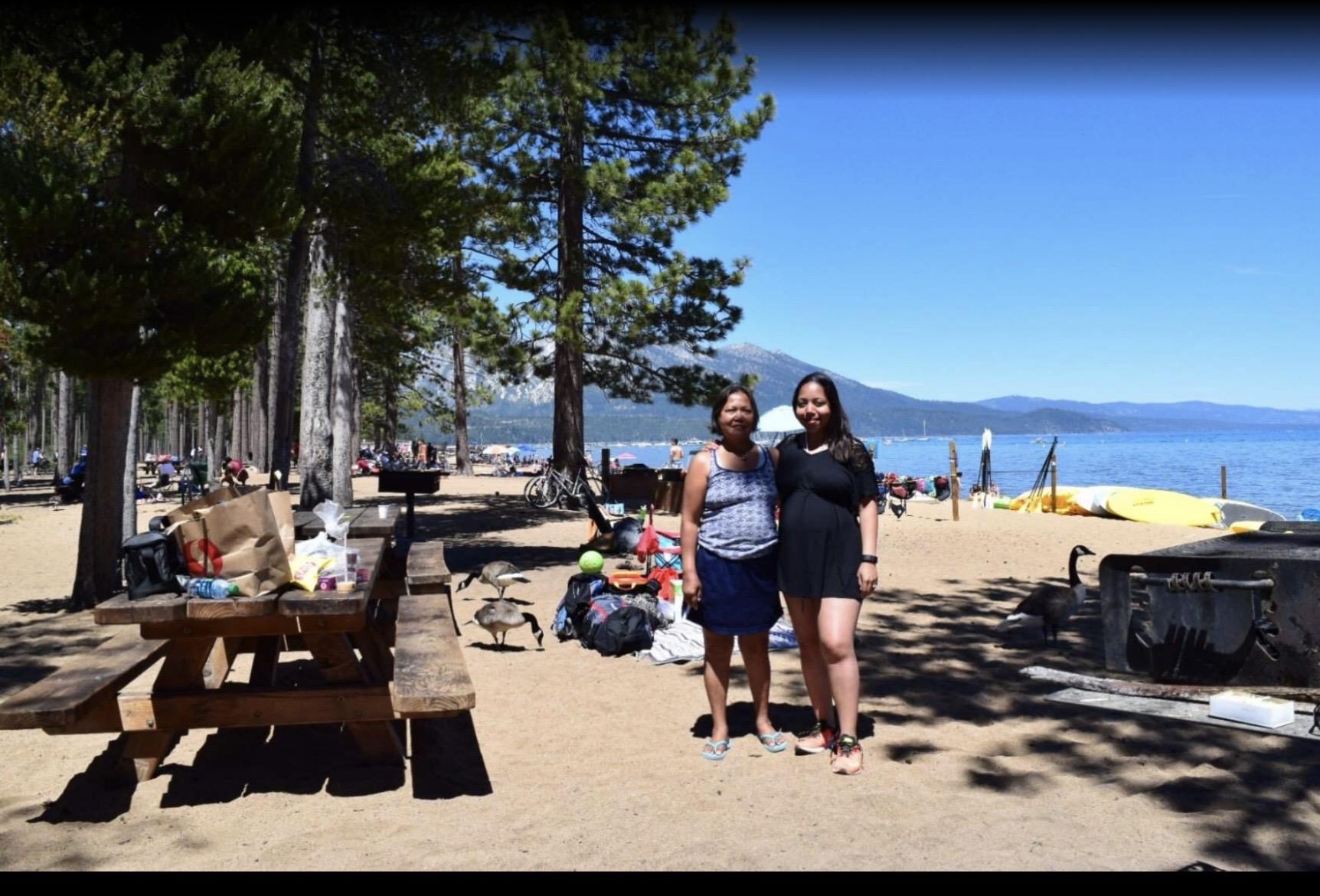 Two women standing next to each other on a beach