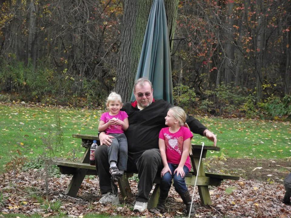 A man sitting on a bench with two children