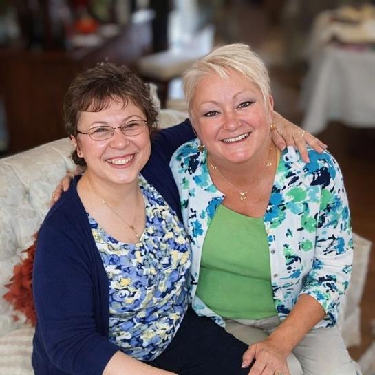 A couple of women sitting on a couch