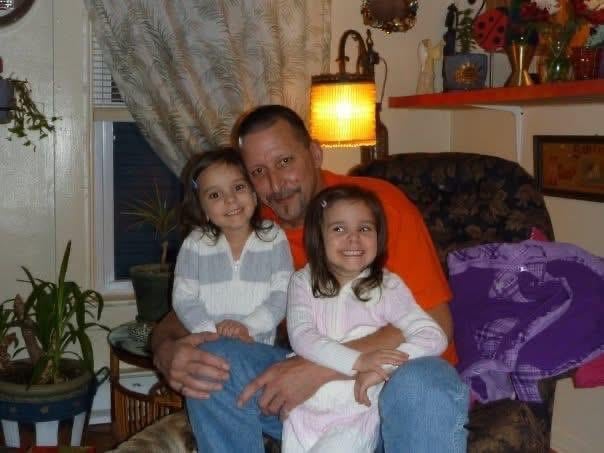 A man and two girls sitting on a couch