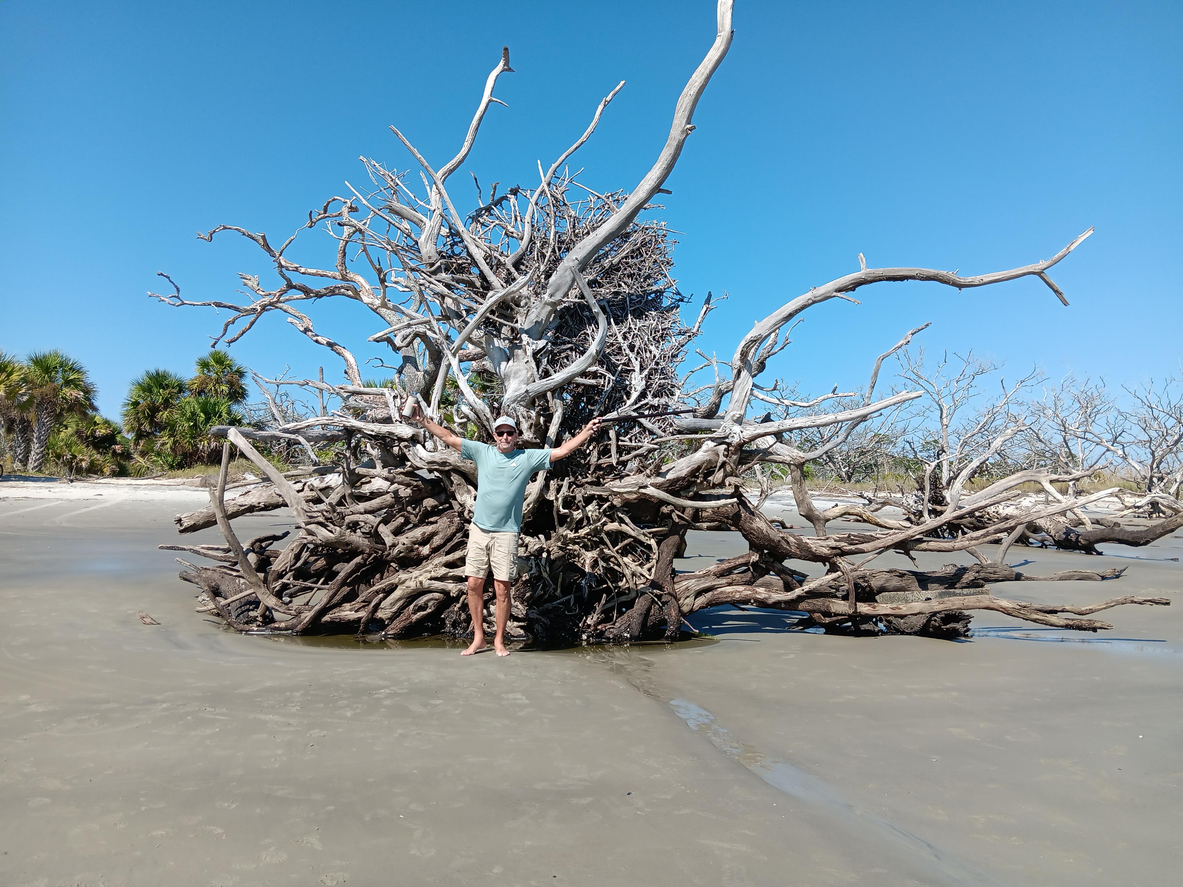 A man standing in front of a large tree