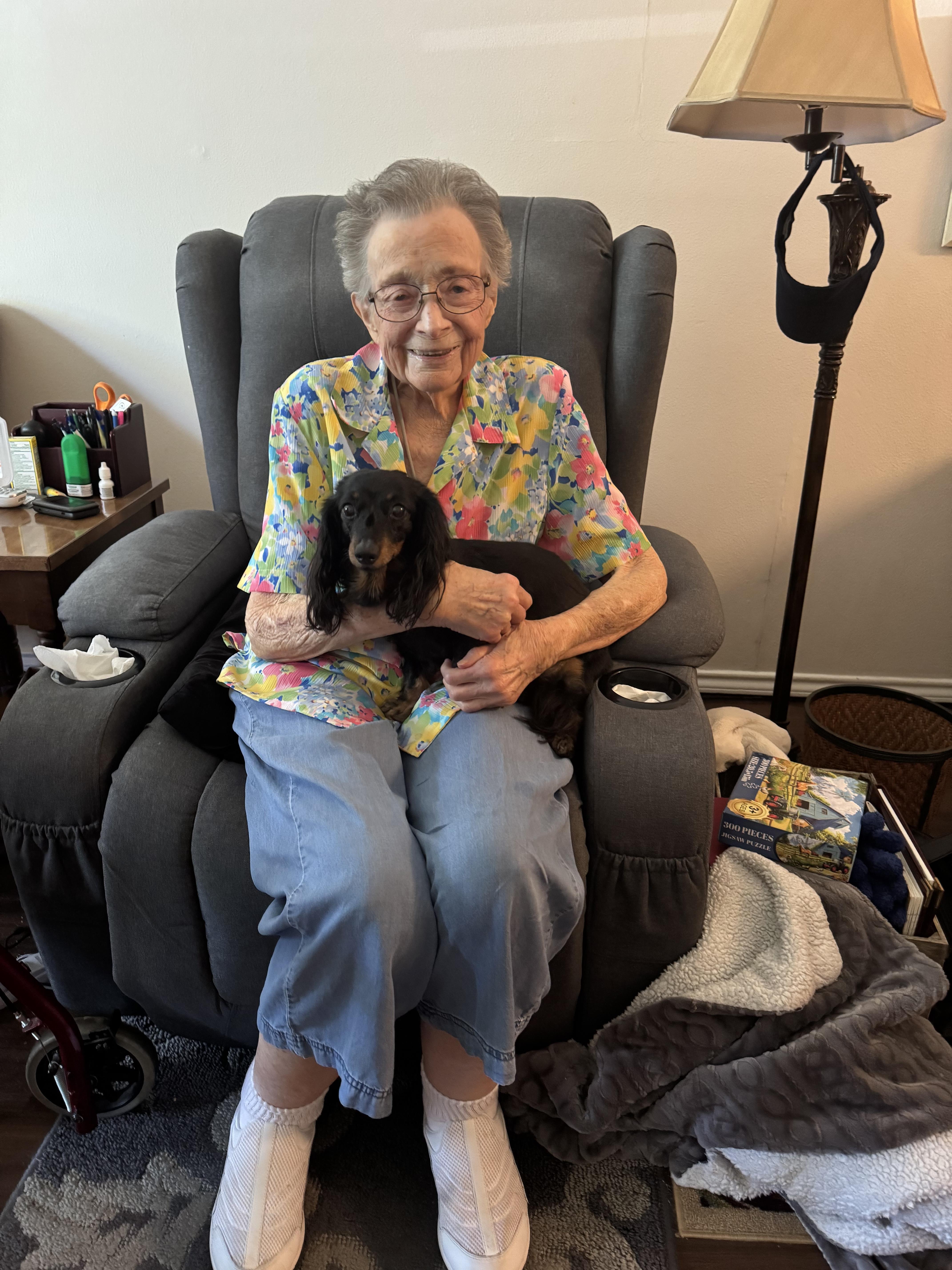 An old woman sitting in a chair holding a dog