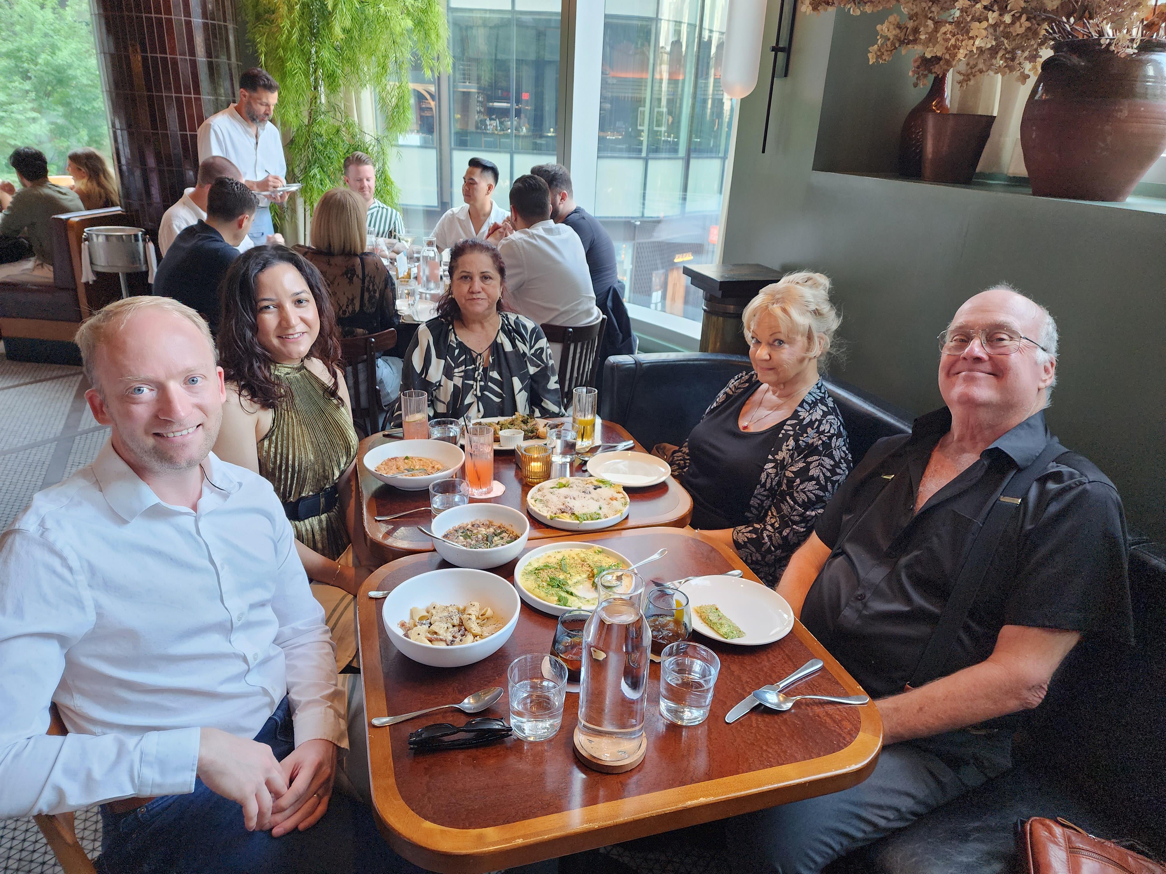 A group of people sitting at a table with food