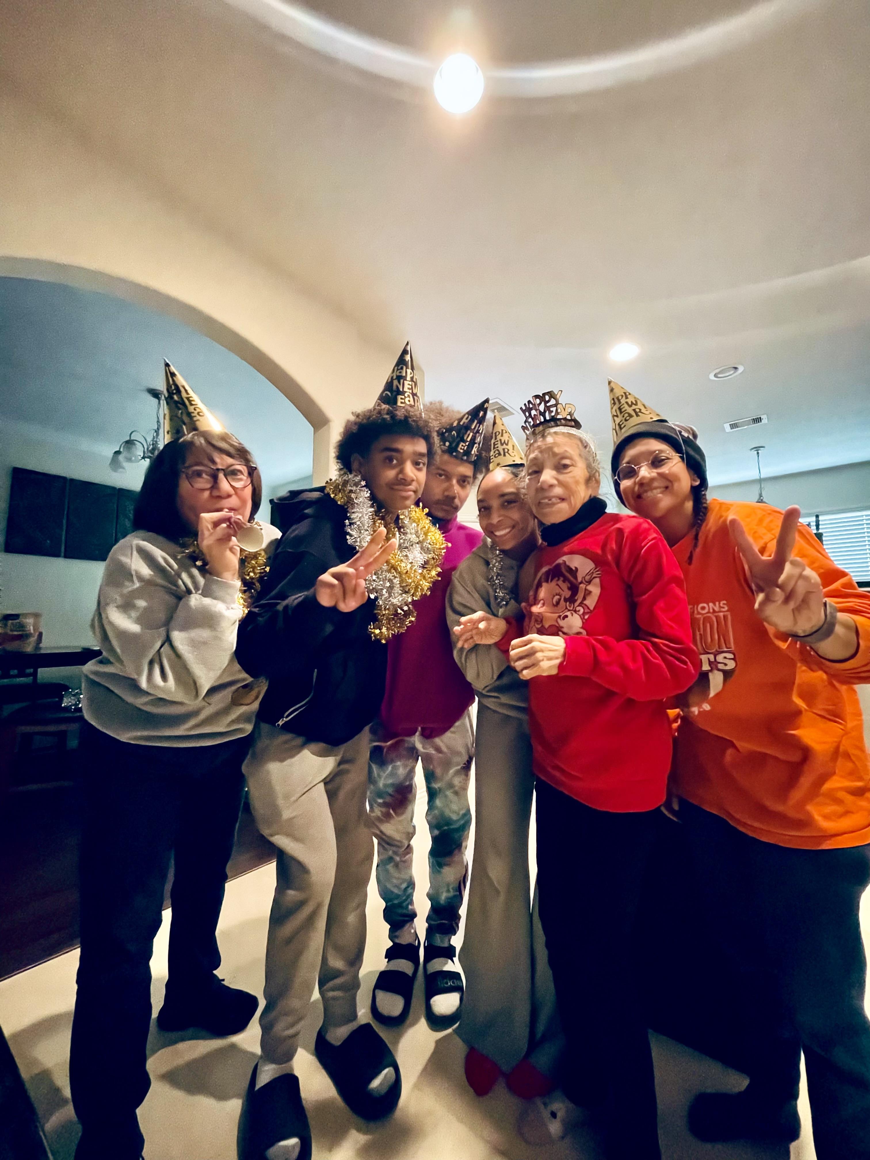 A group of people wearing party hats and smiling