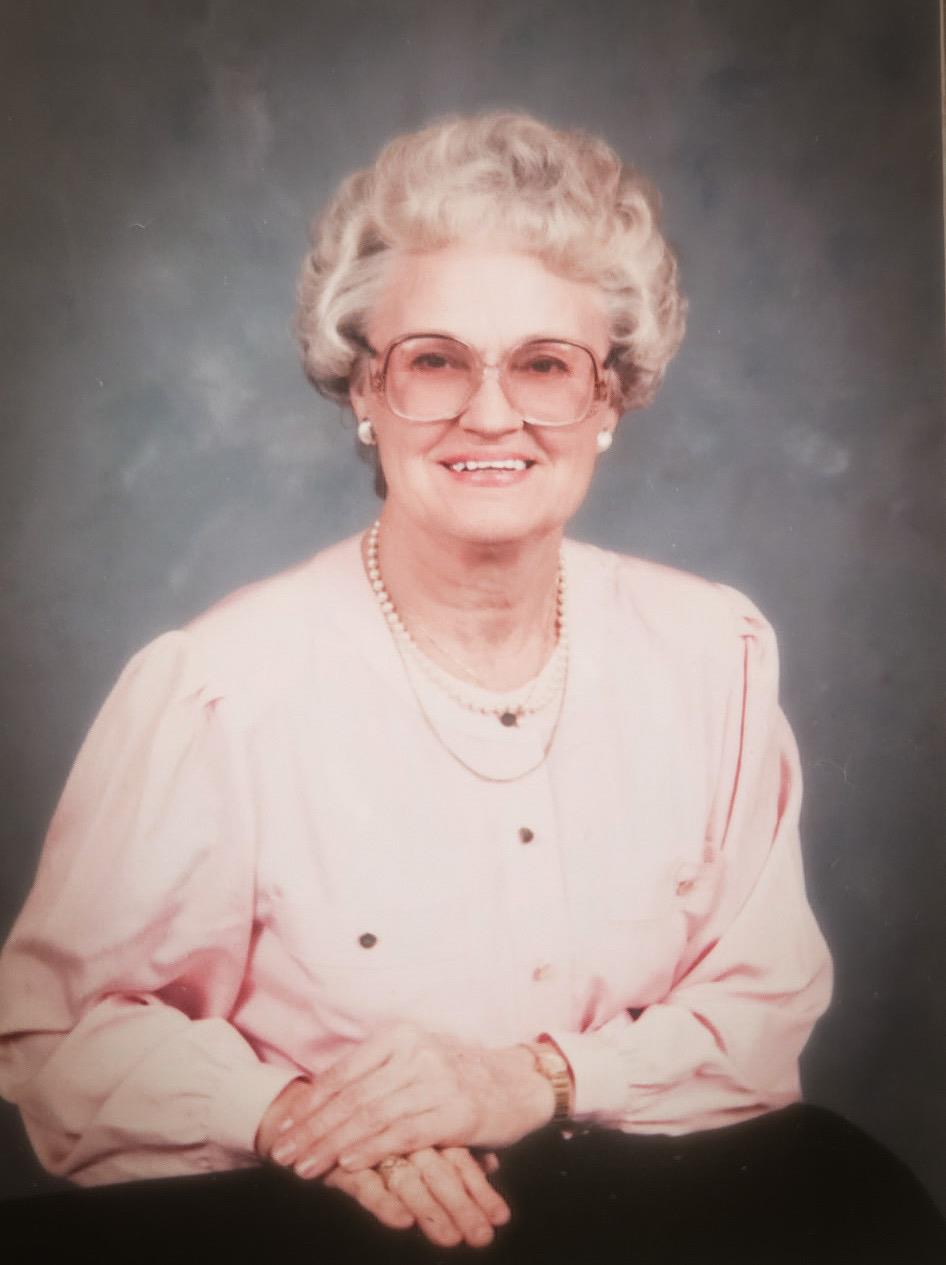 A woman wearing glasses and a pink blouse