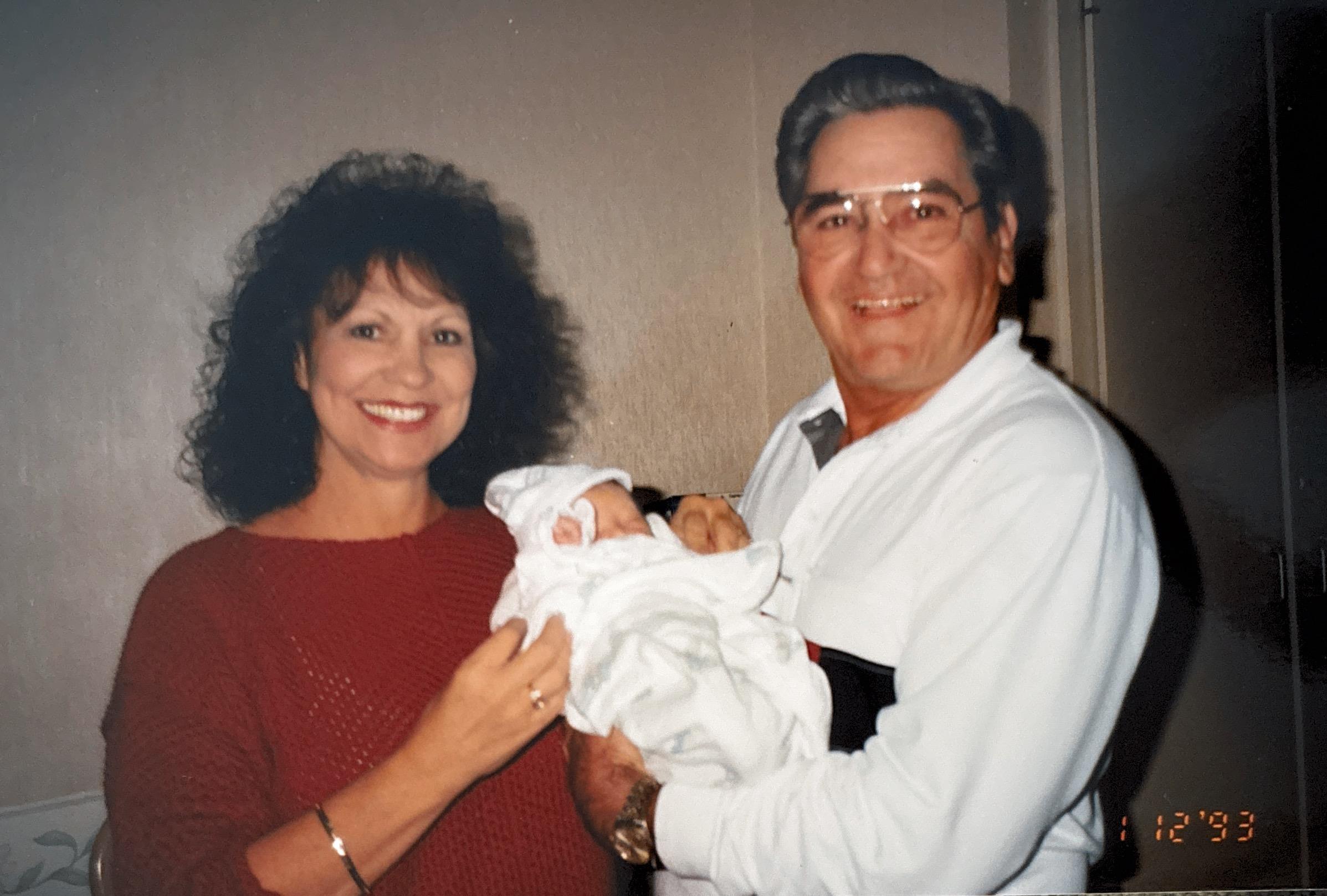 A man and woman holding a baby
