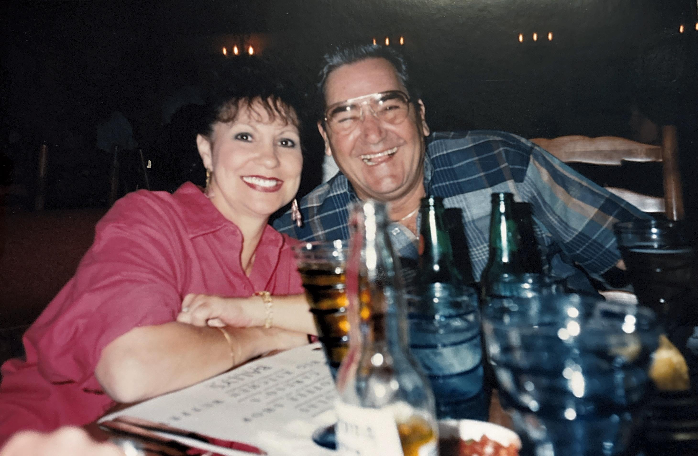 A man and woman sitting at a table with drinks