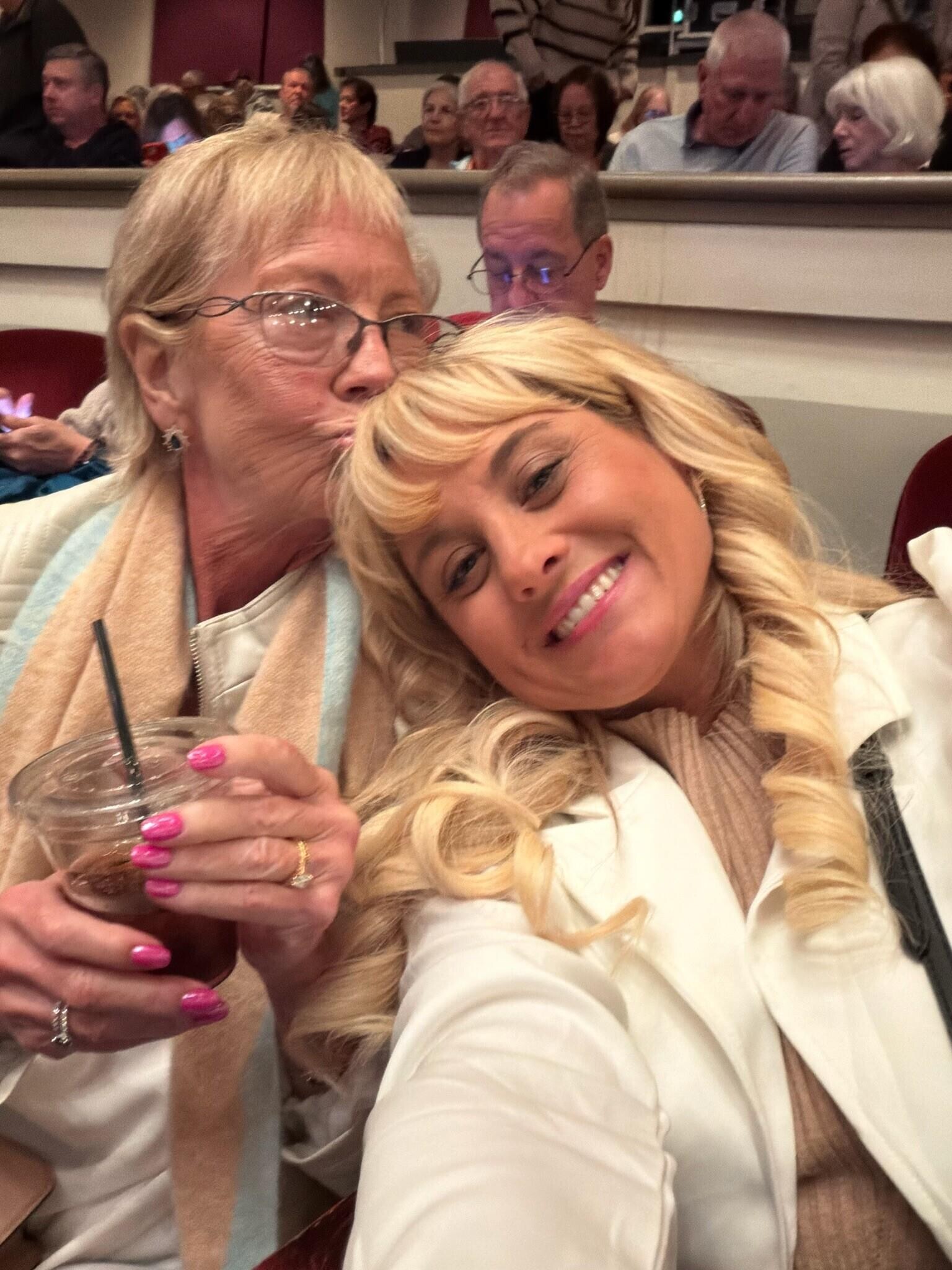 A woman taking a selfie with another woman