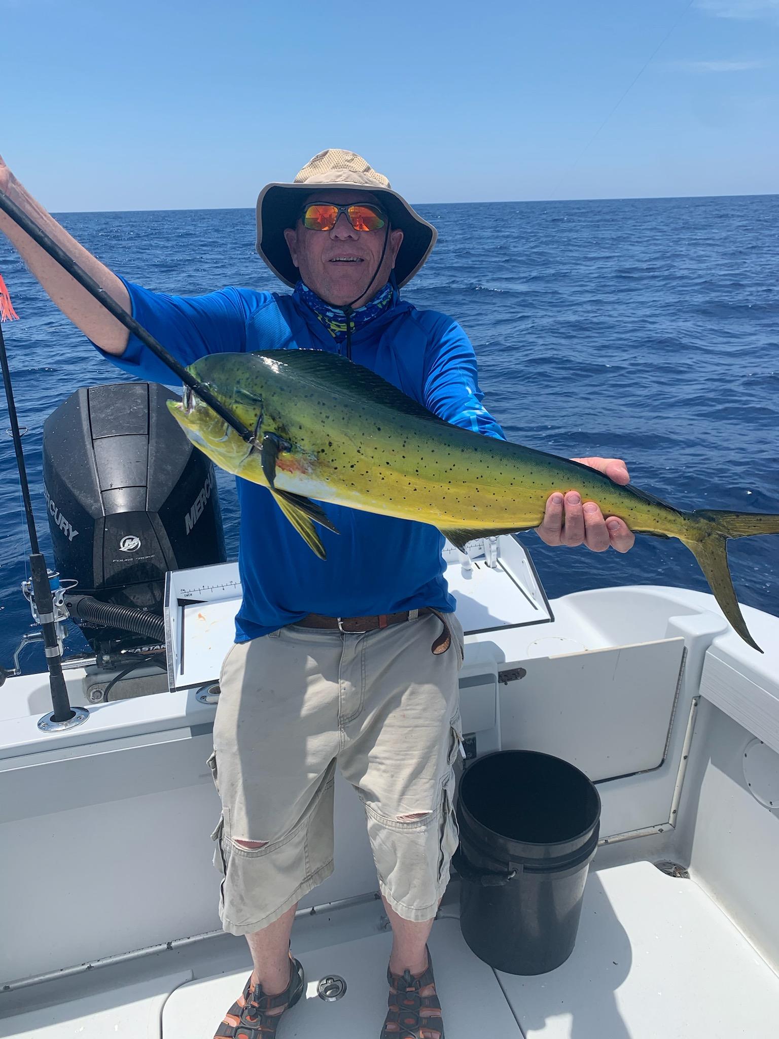 A man holding a fish on a boat