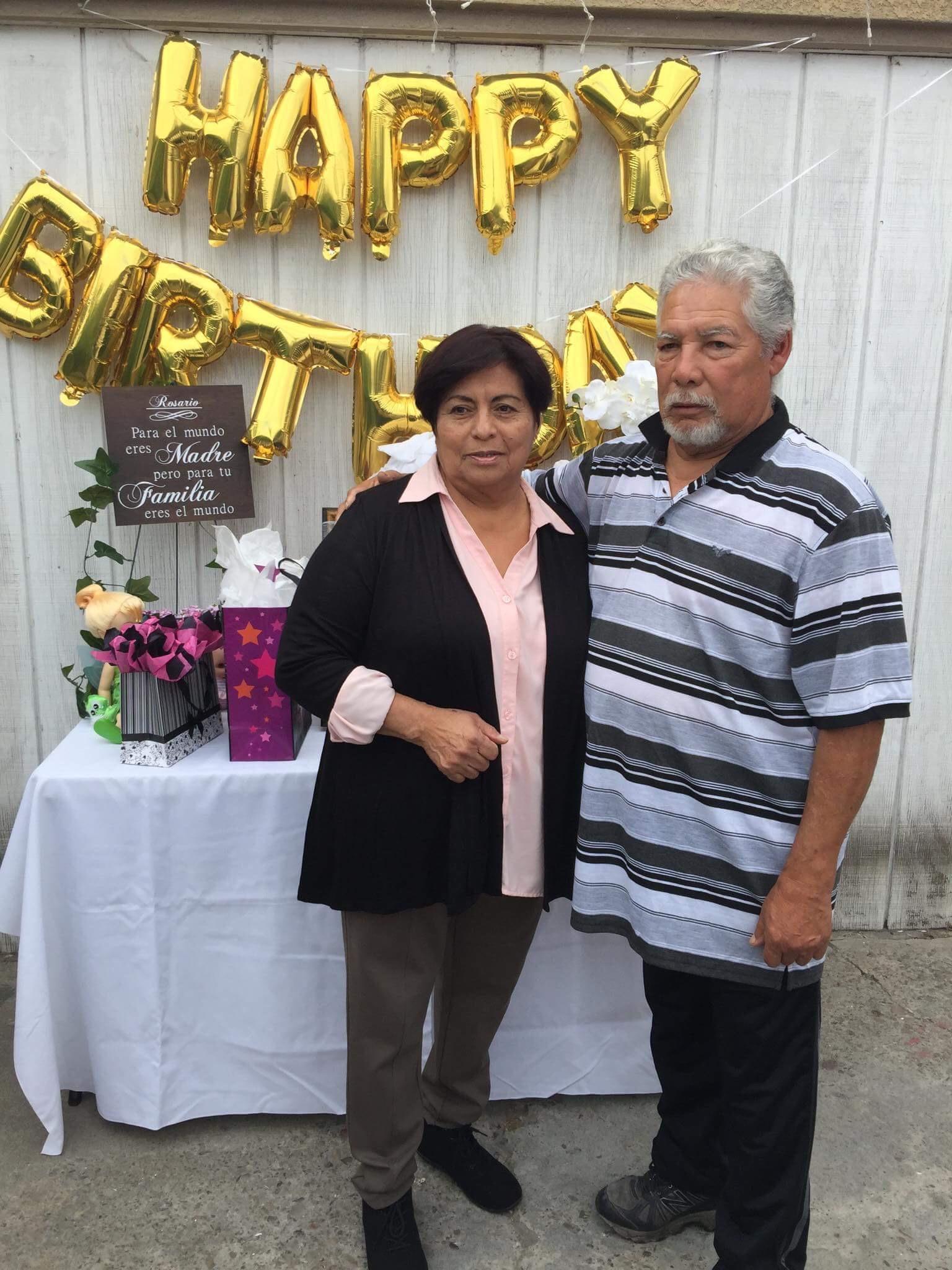 A man and woman standing in front of a sign