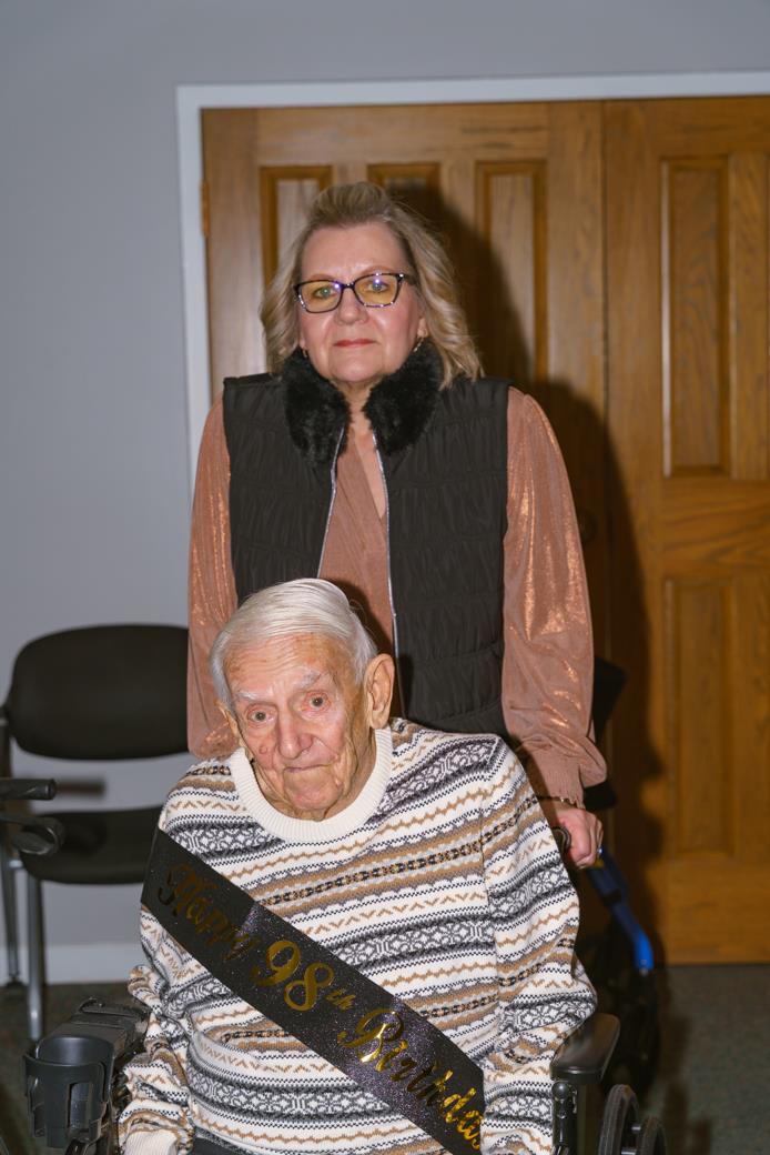 A woman standing next to an elderly man