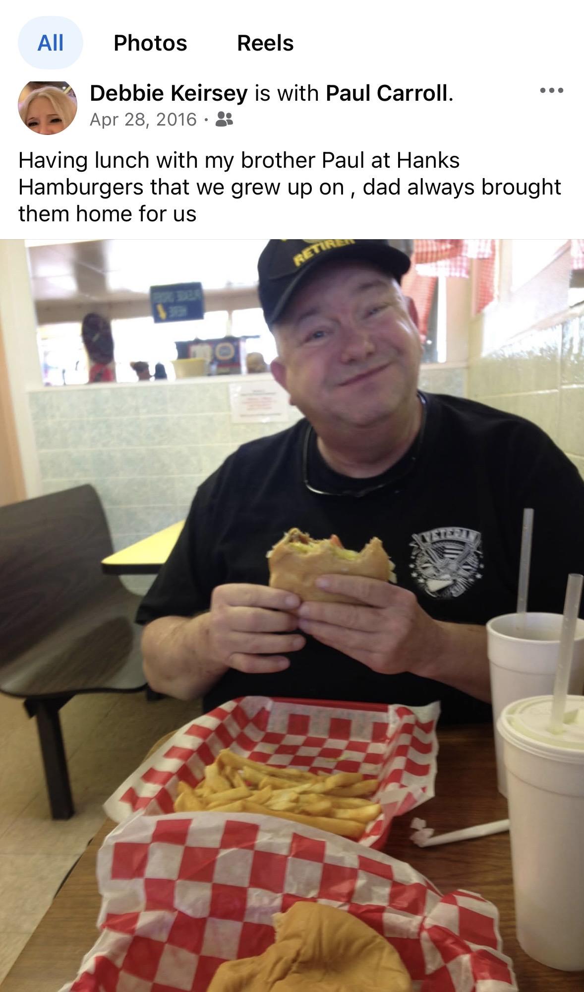 A man smiling at a table with food