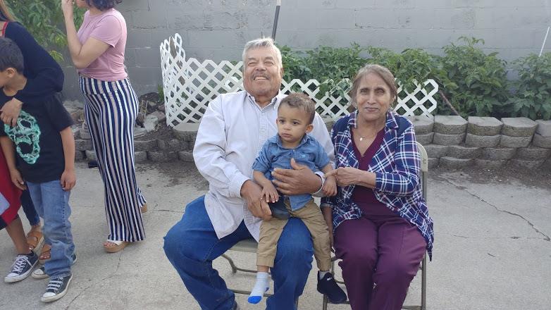 A man and woman sitting on a chair with a child
