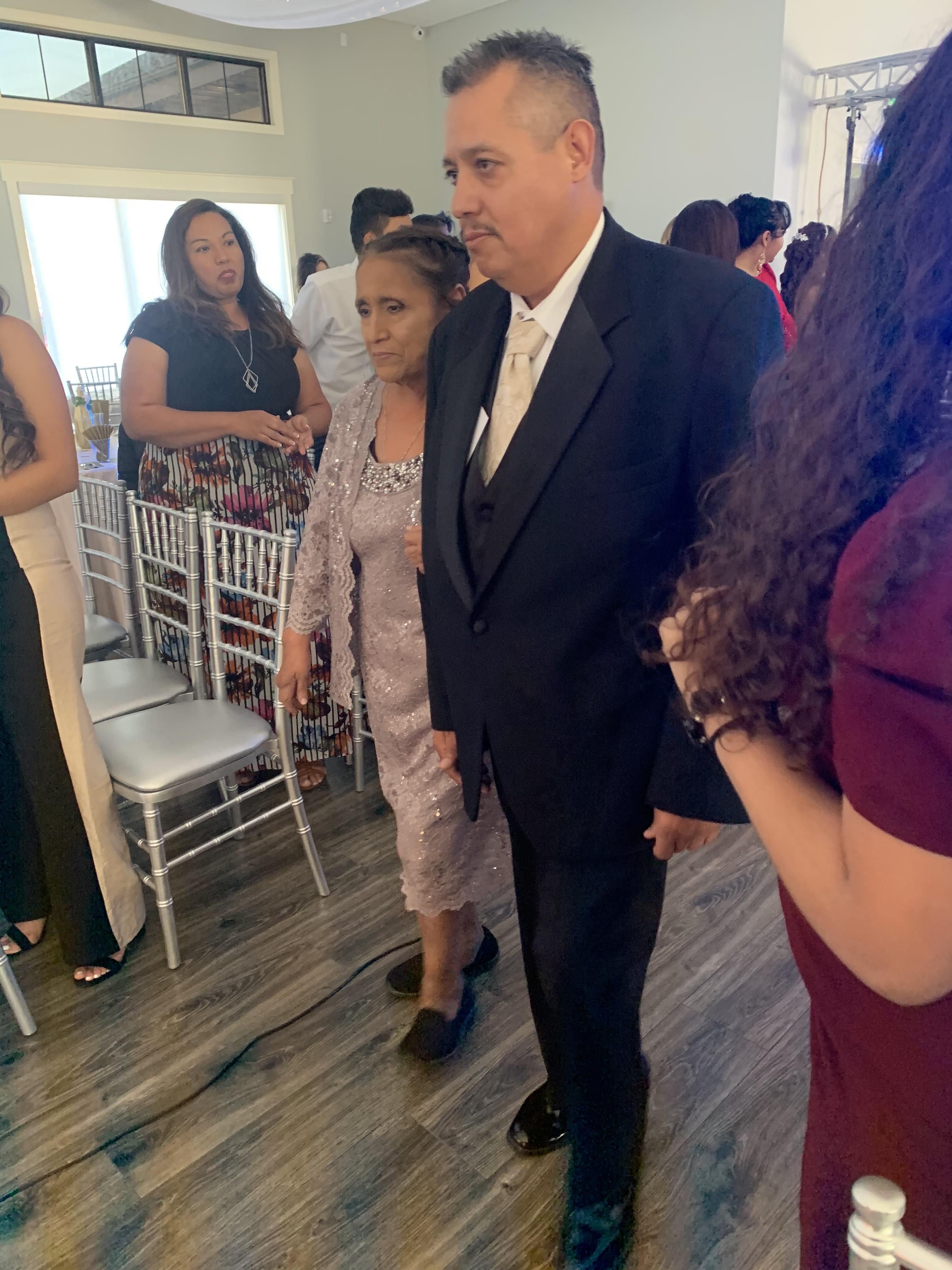 A man in a suit and tie standing in a room with people around