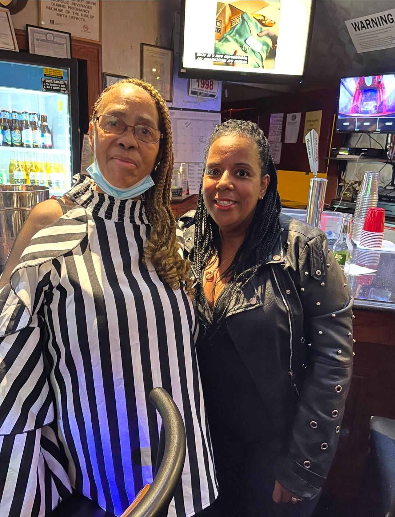 Two women standing together in a bar