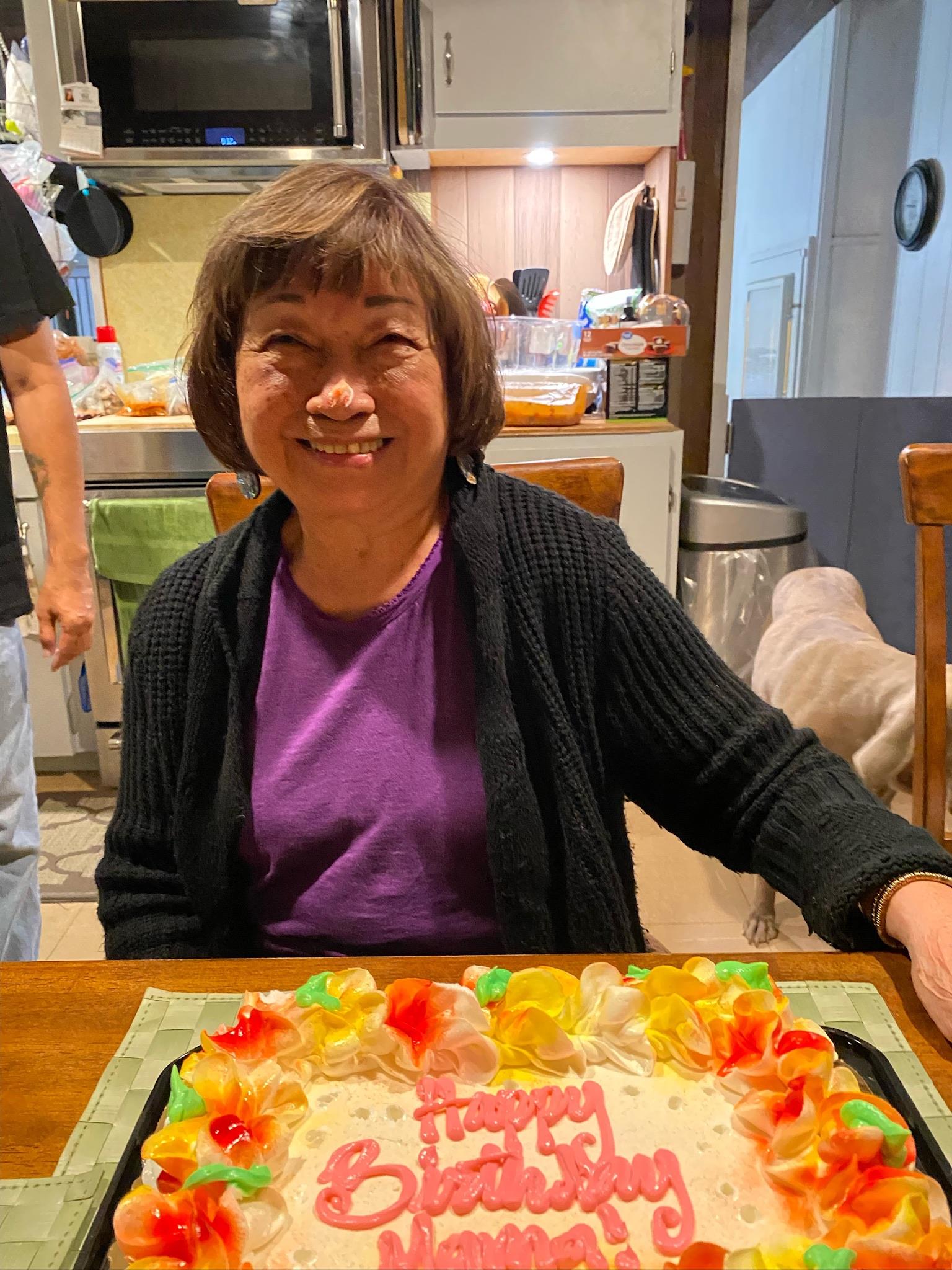 A woman sitting at a table with a cake