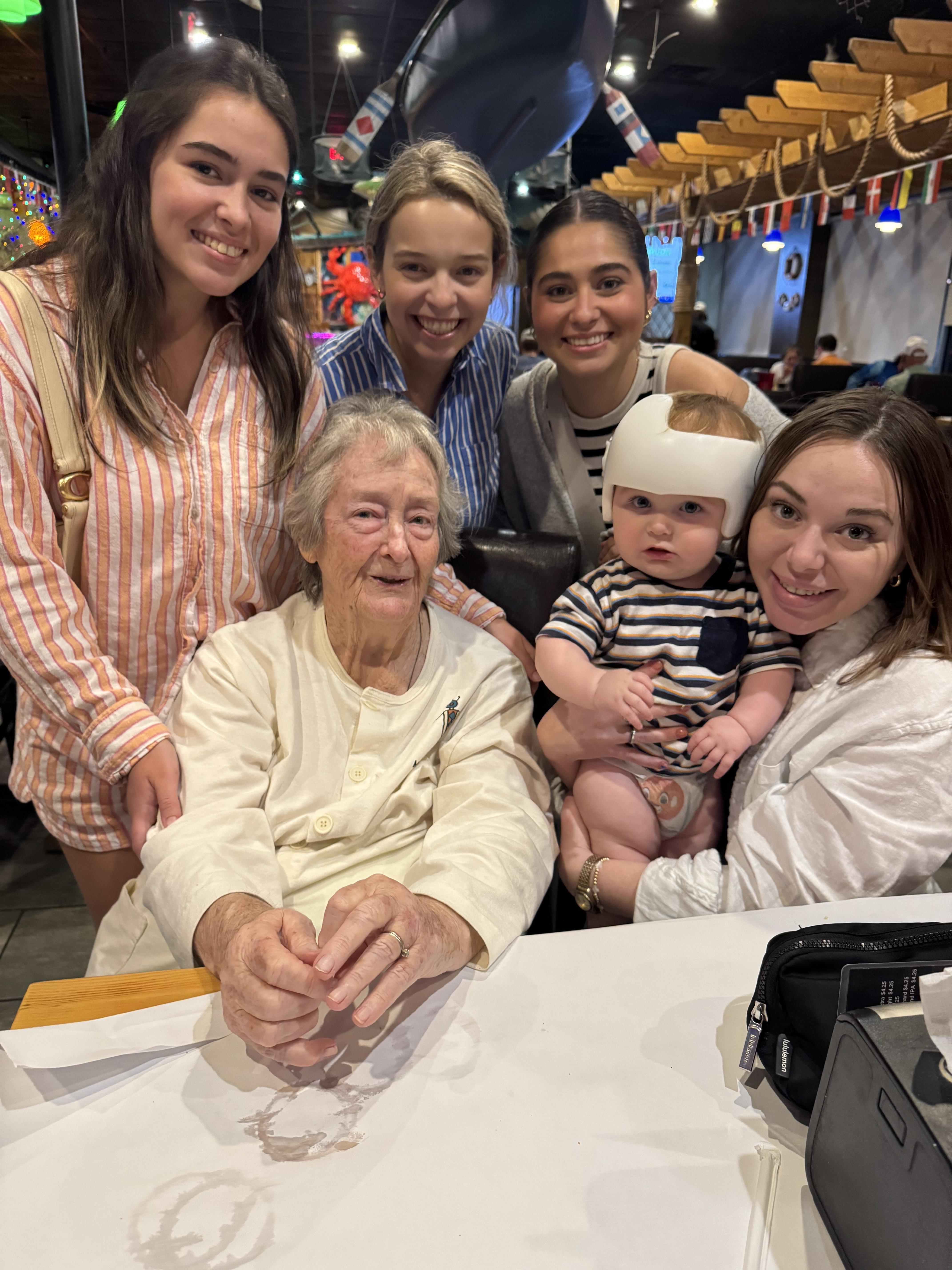 A group of women and an old woman posing for a photo