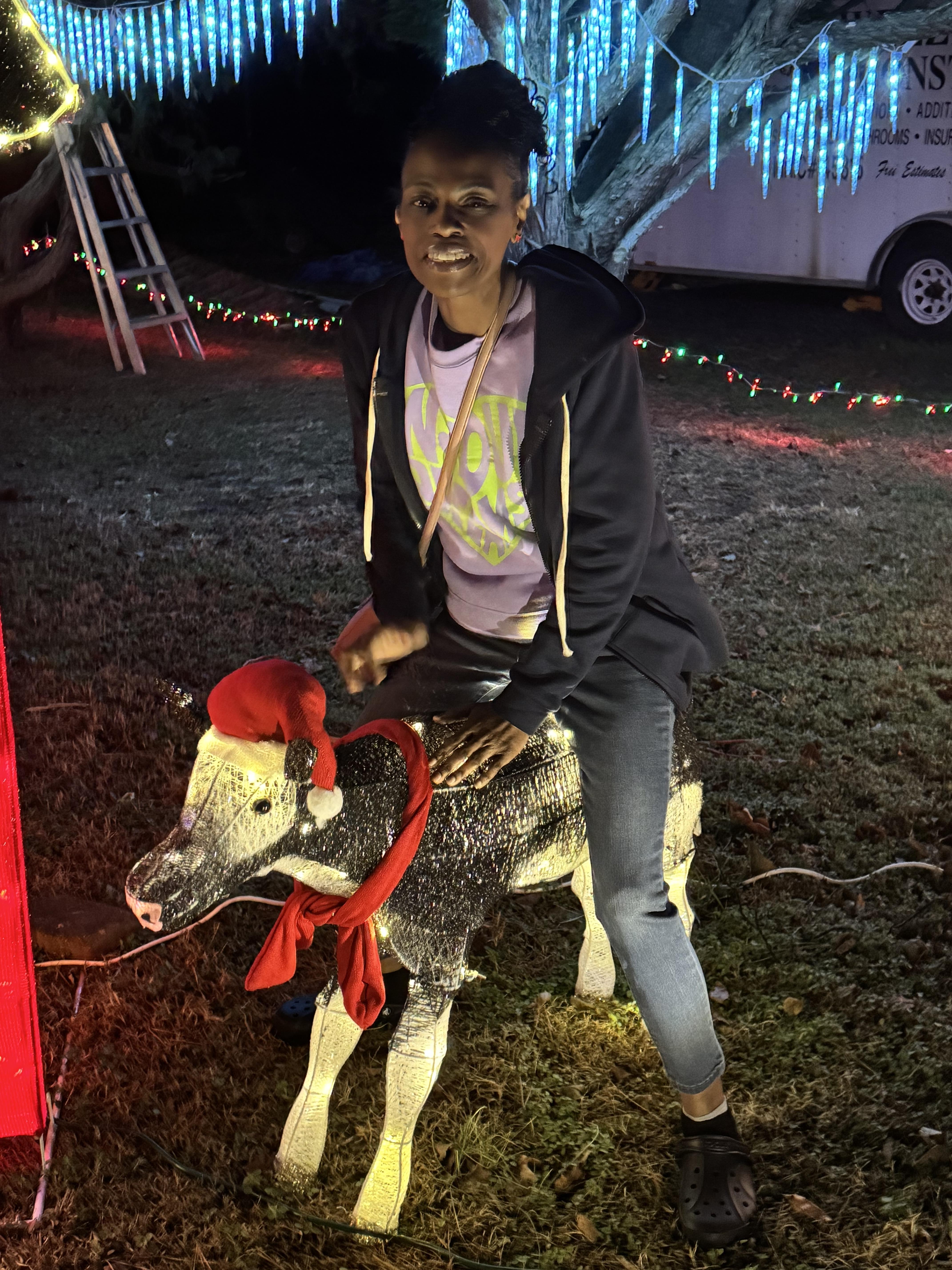 A woman sitting on a statue of a cow