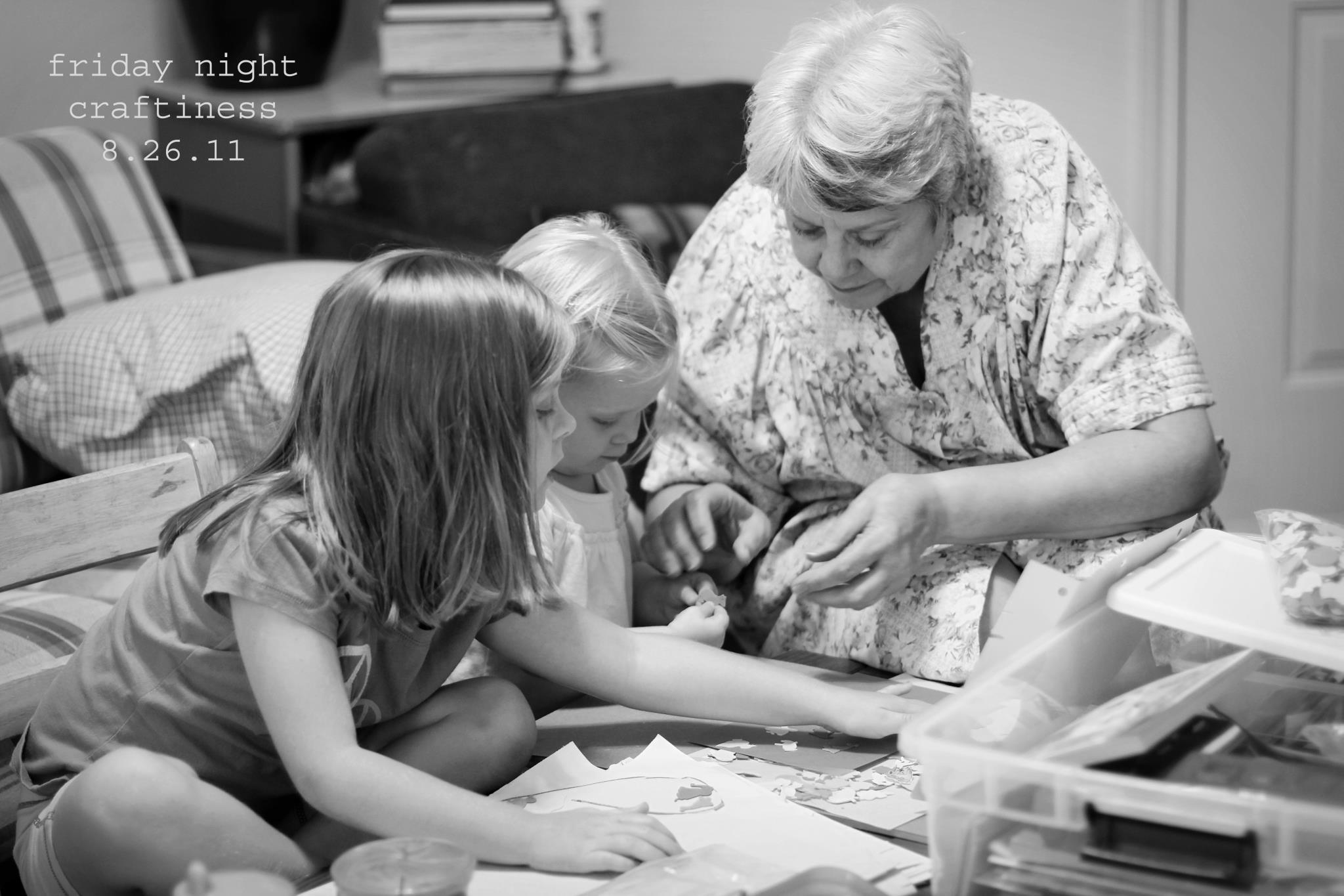A woman and two young girls sitting on the floor