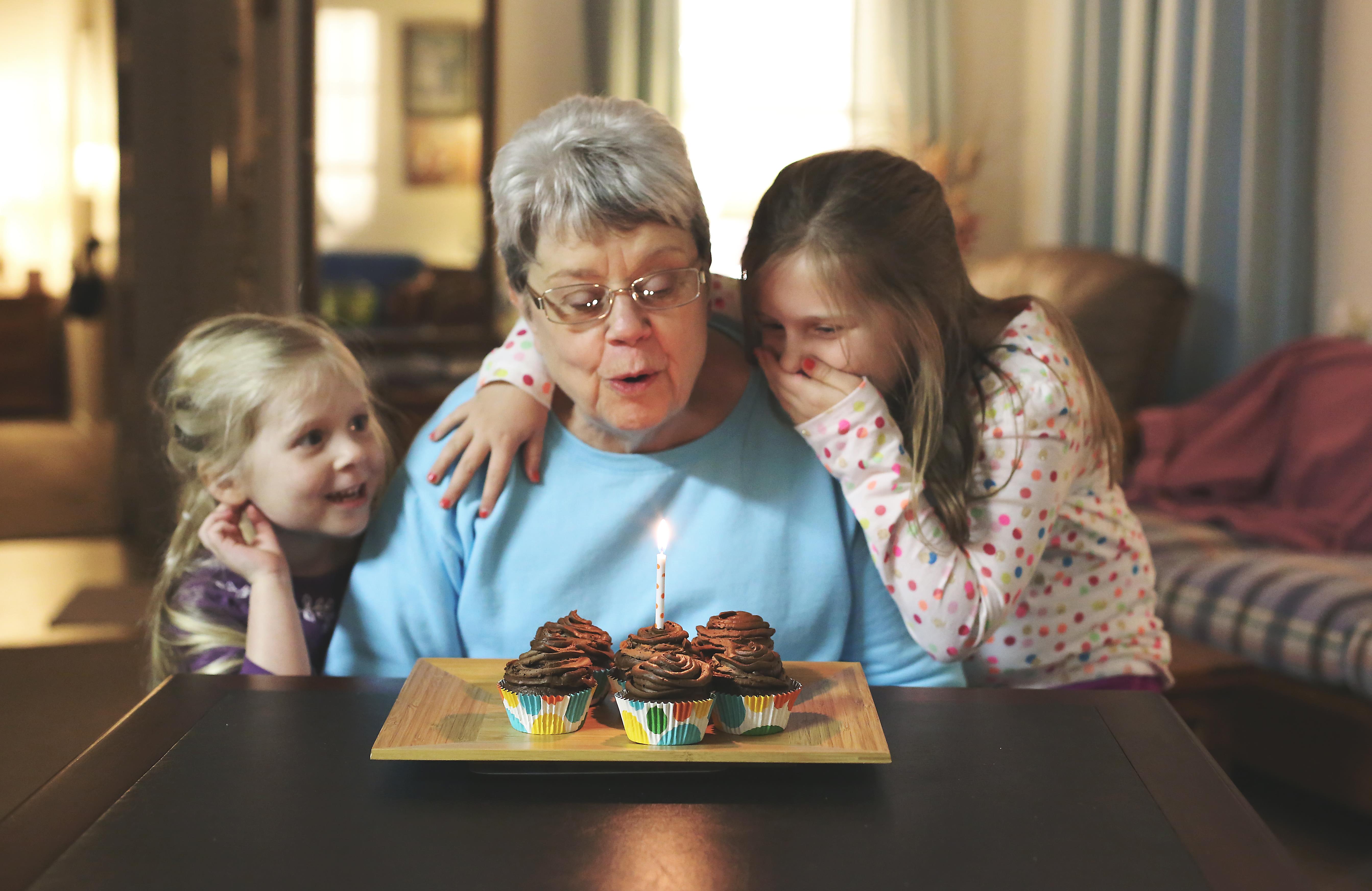 A woman and two girls with cupcakes