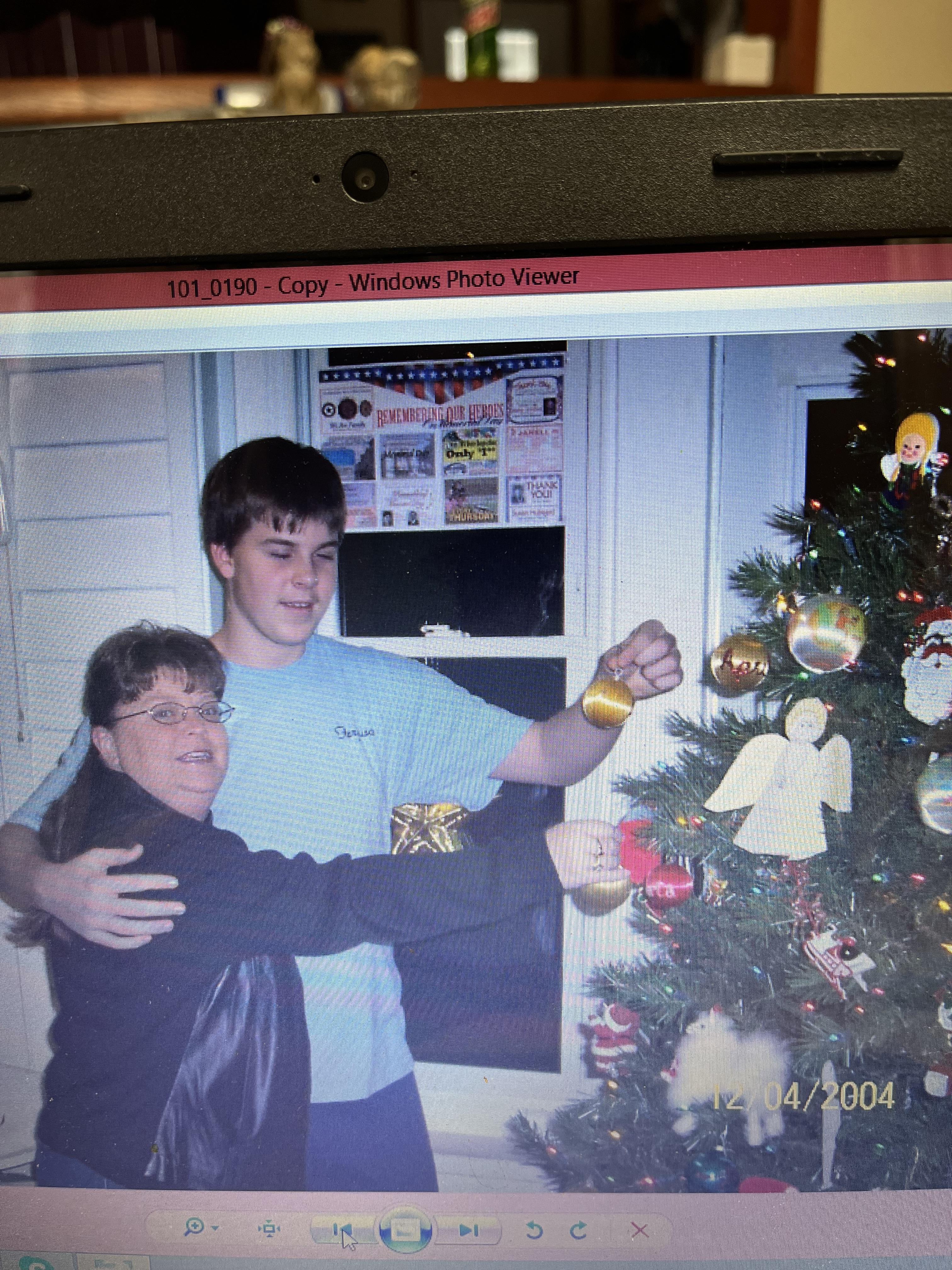 A man and woman standing next to a christmas tree