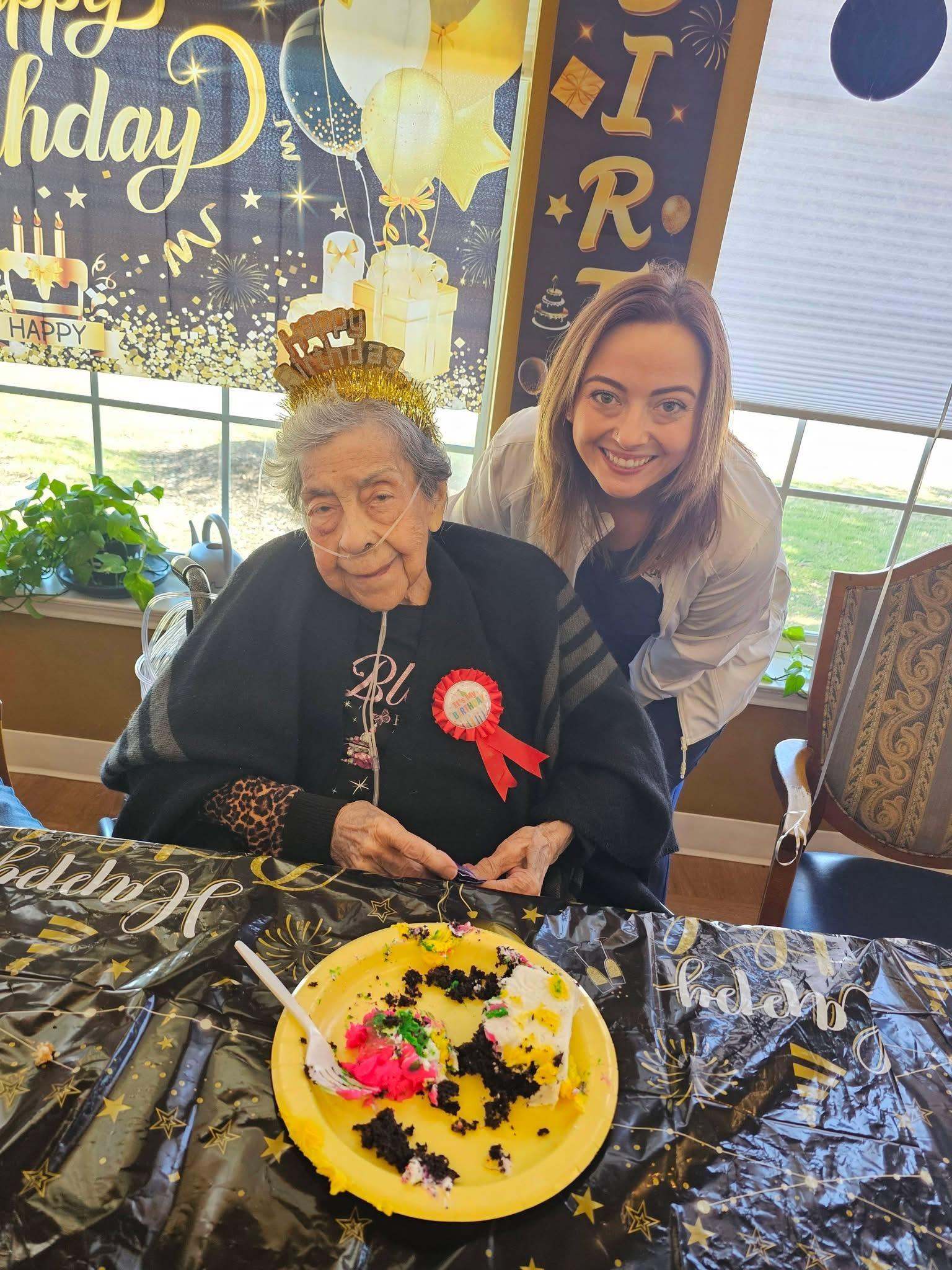 A woman sitting at a table with a cake on it