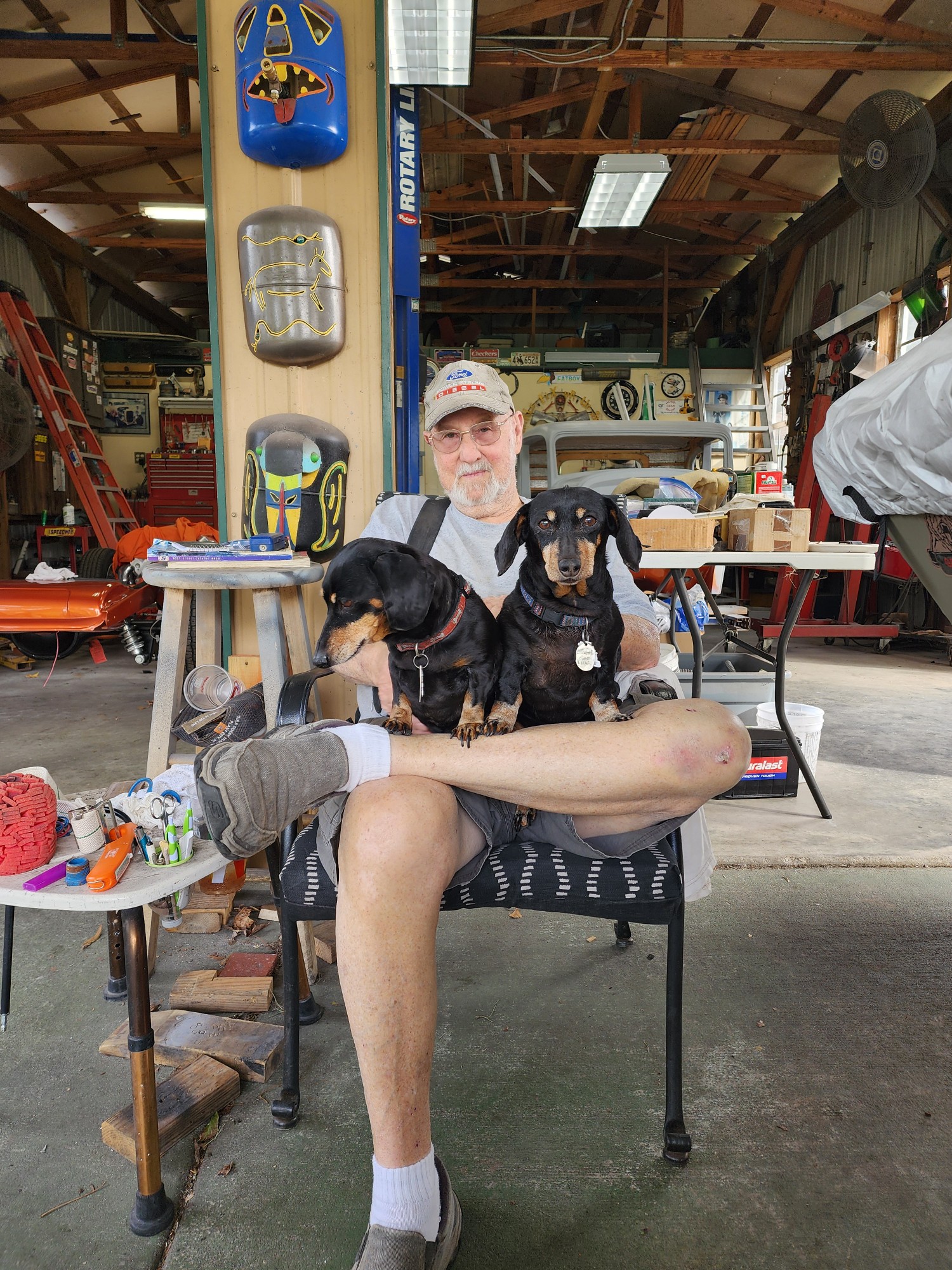 A man sitting in a chair with two dogs
